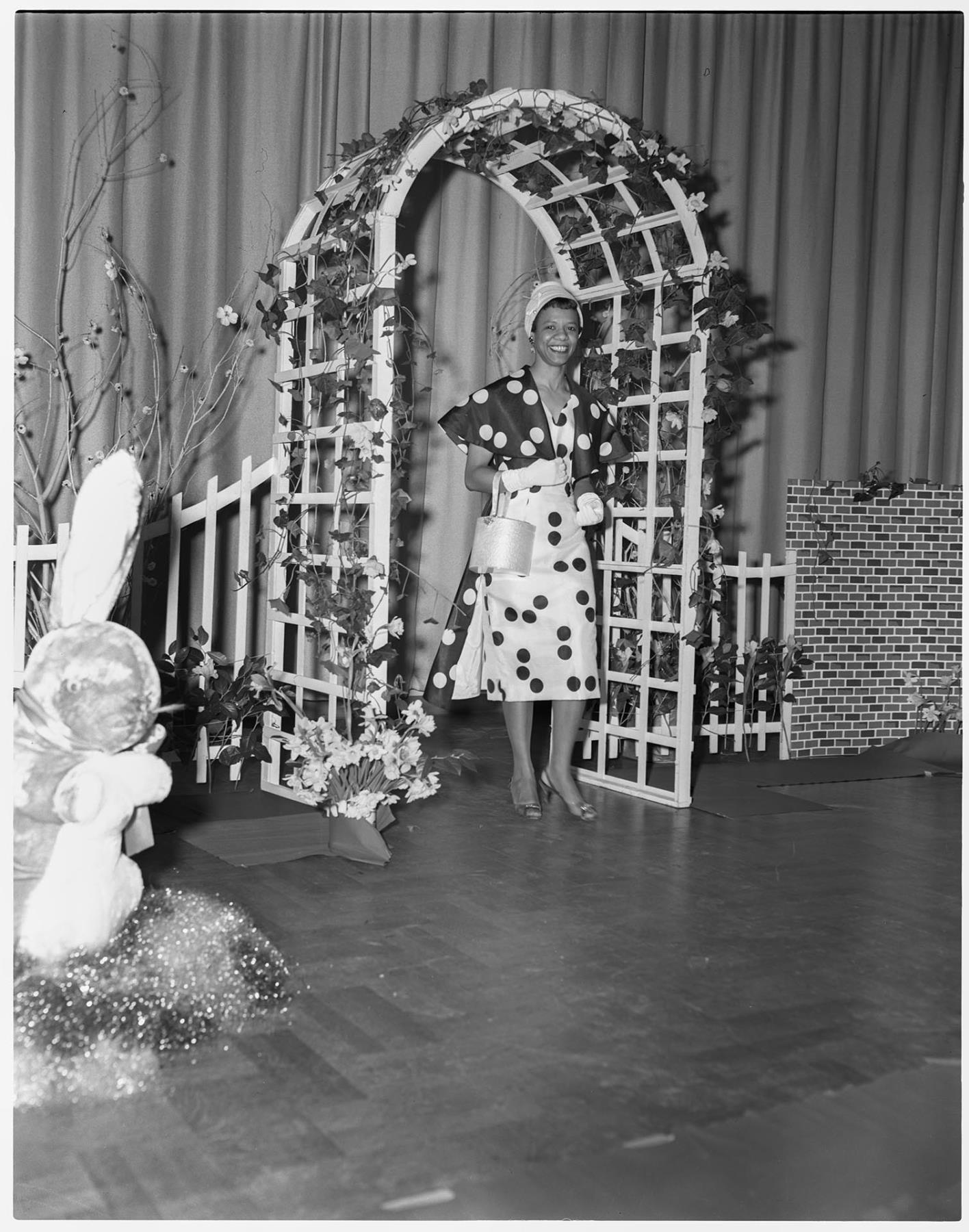 Image of Model under trellis at a fashion show, Seattle, circa 1953