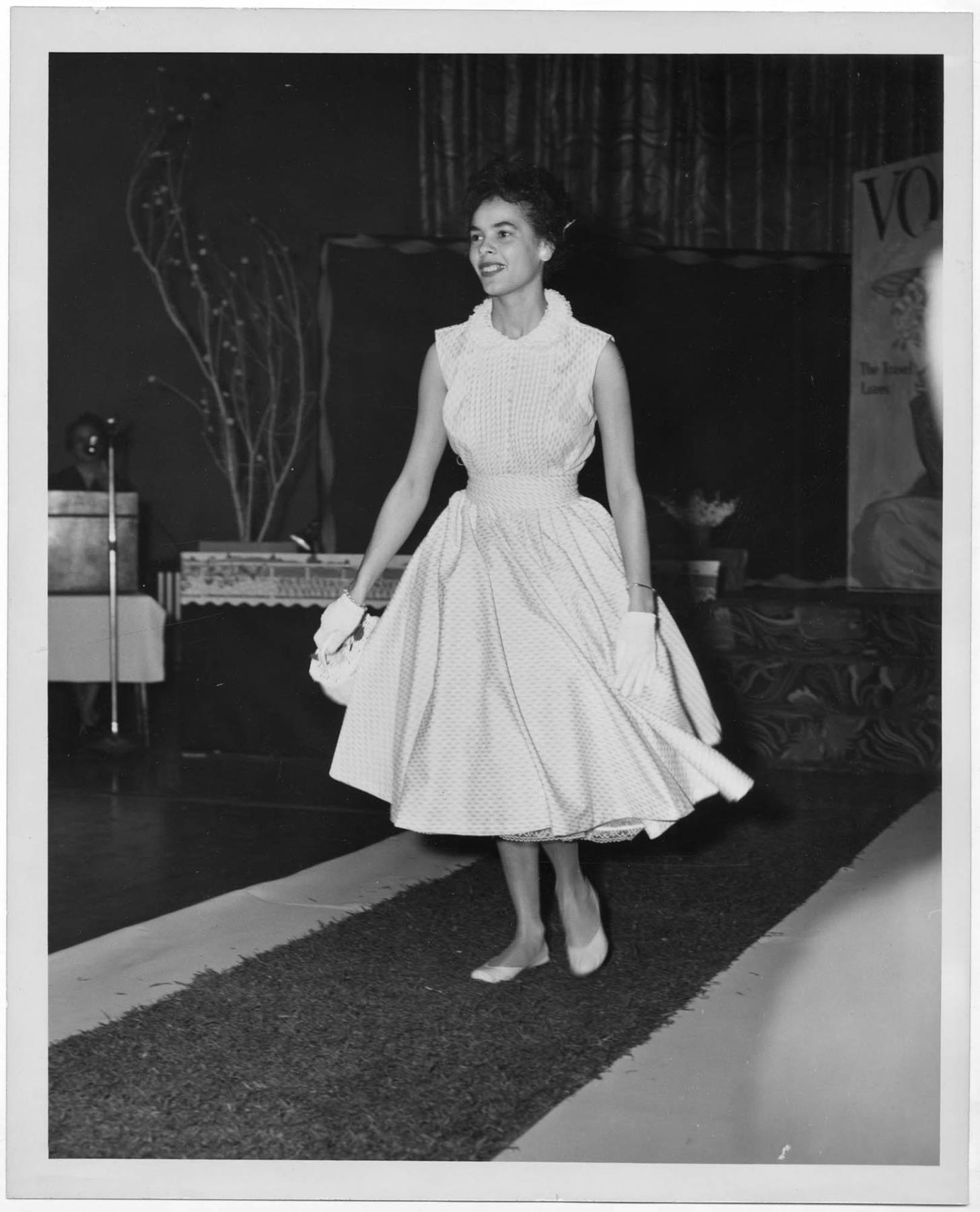 Image of Woman modeling dress at fashion show, circa 1955