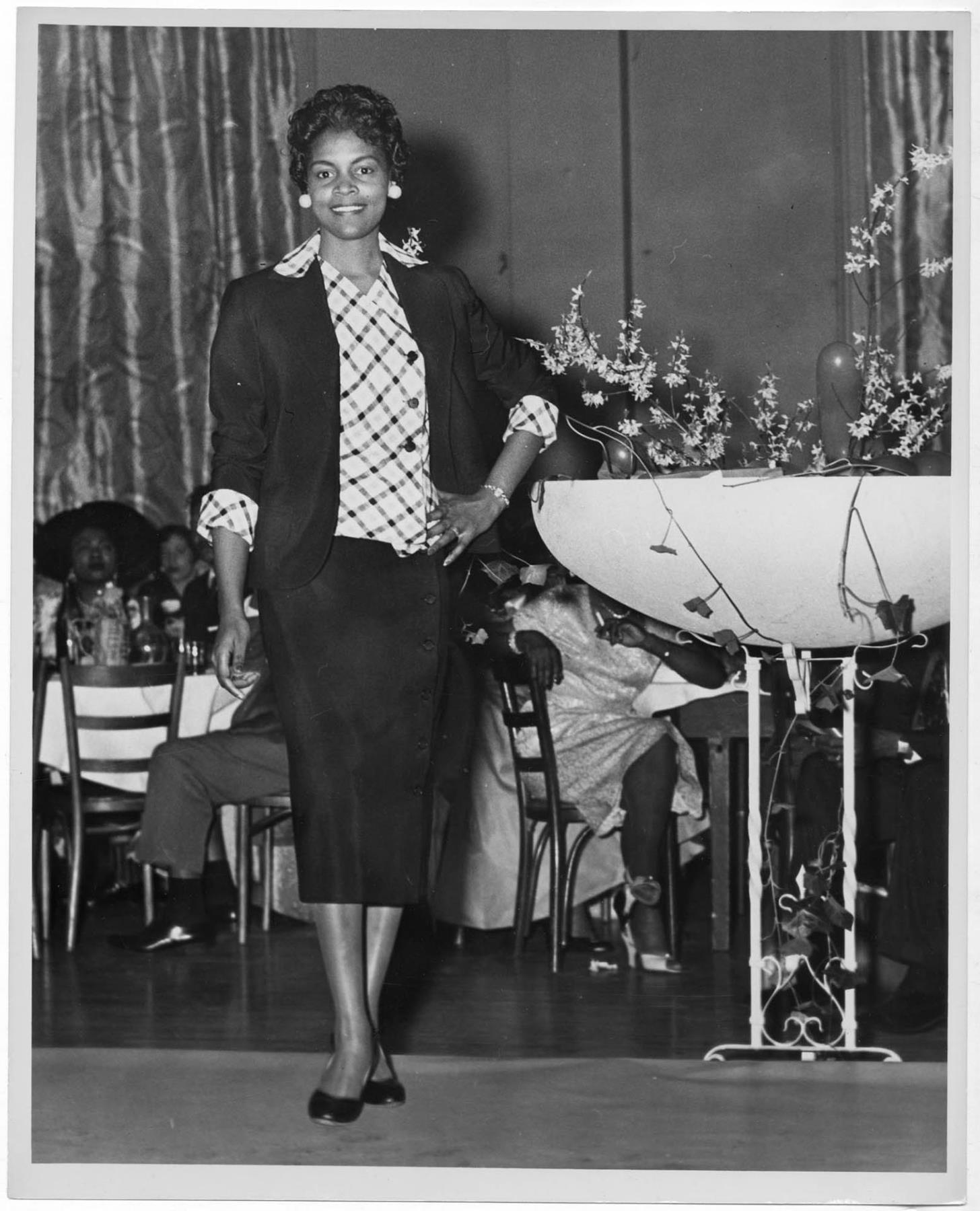 Image of Woman modeling outfit at fashion show, circa 1955
