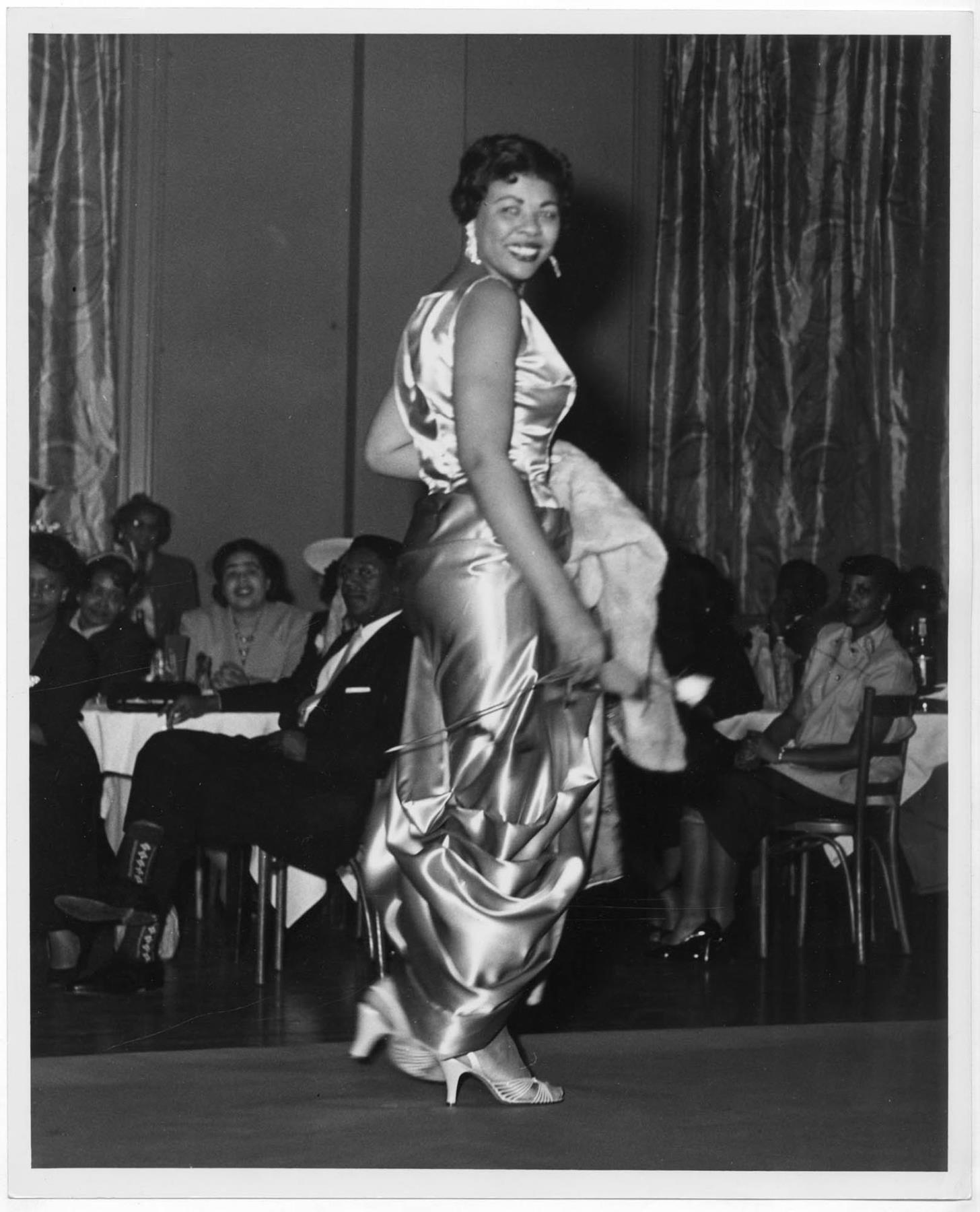 Image of Woman modeling dress at fashion show, circa 1955