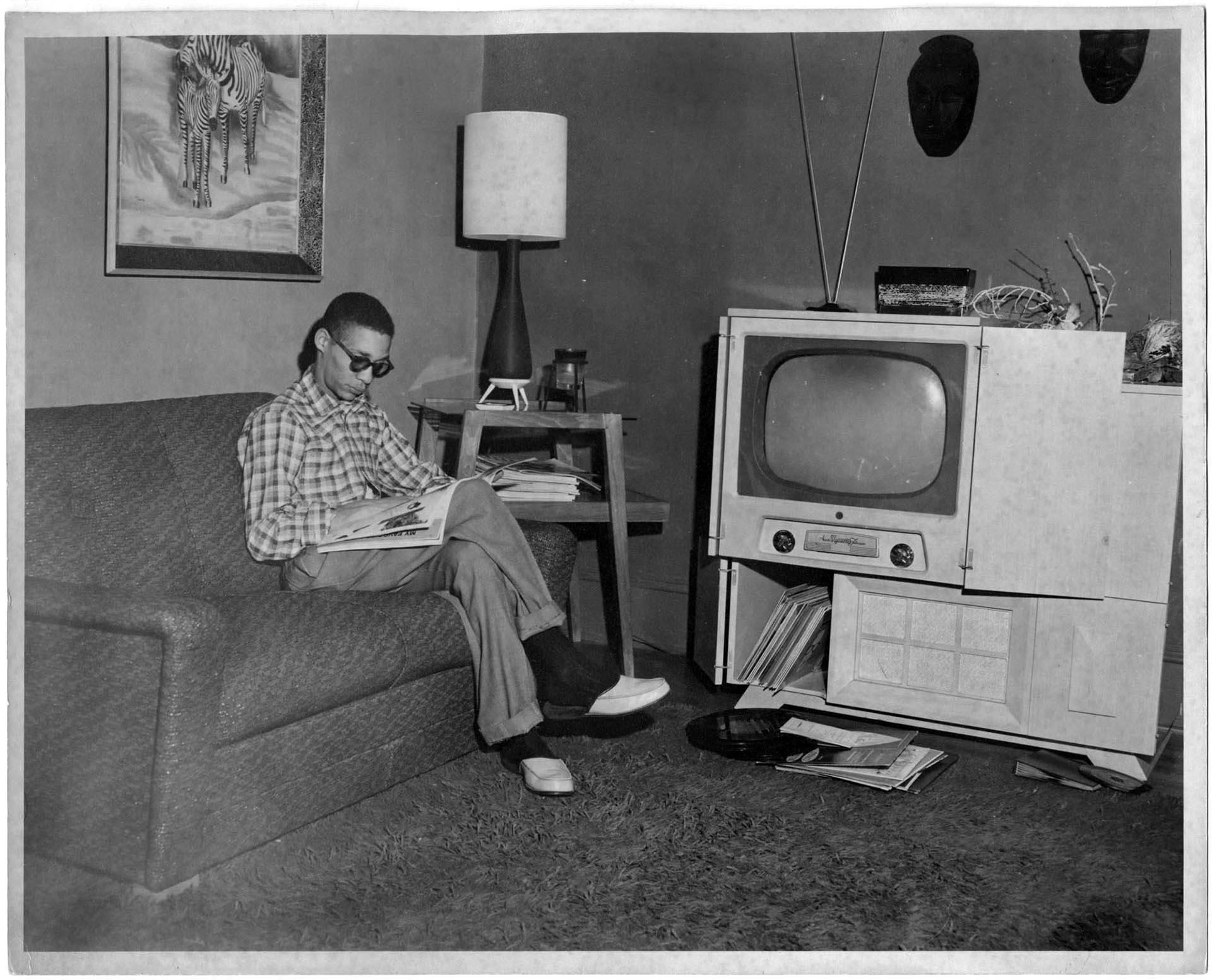 Image of Buddy Brashear sitting on living room couch, circa 1950