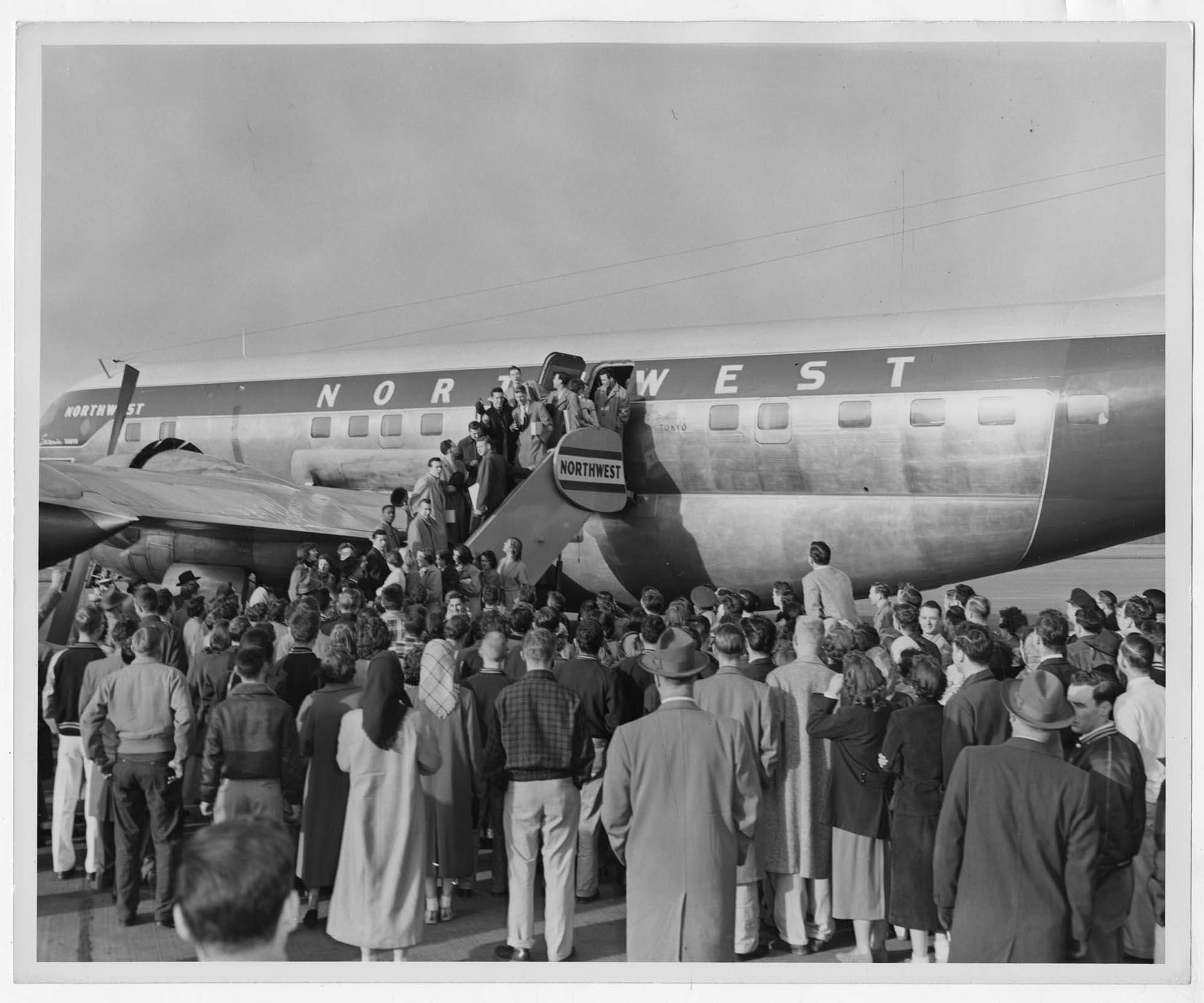 Image of Northwest Airlines plane with passengers on the boarding ramp, Seattle, circa 1950