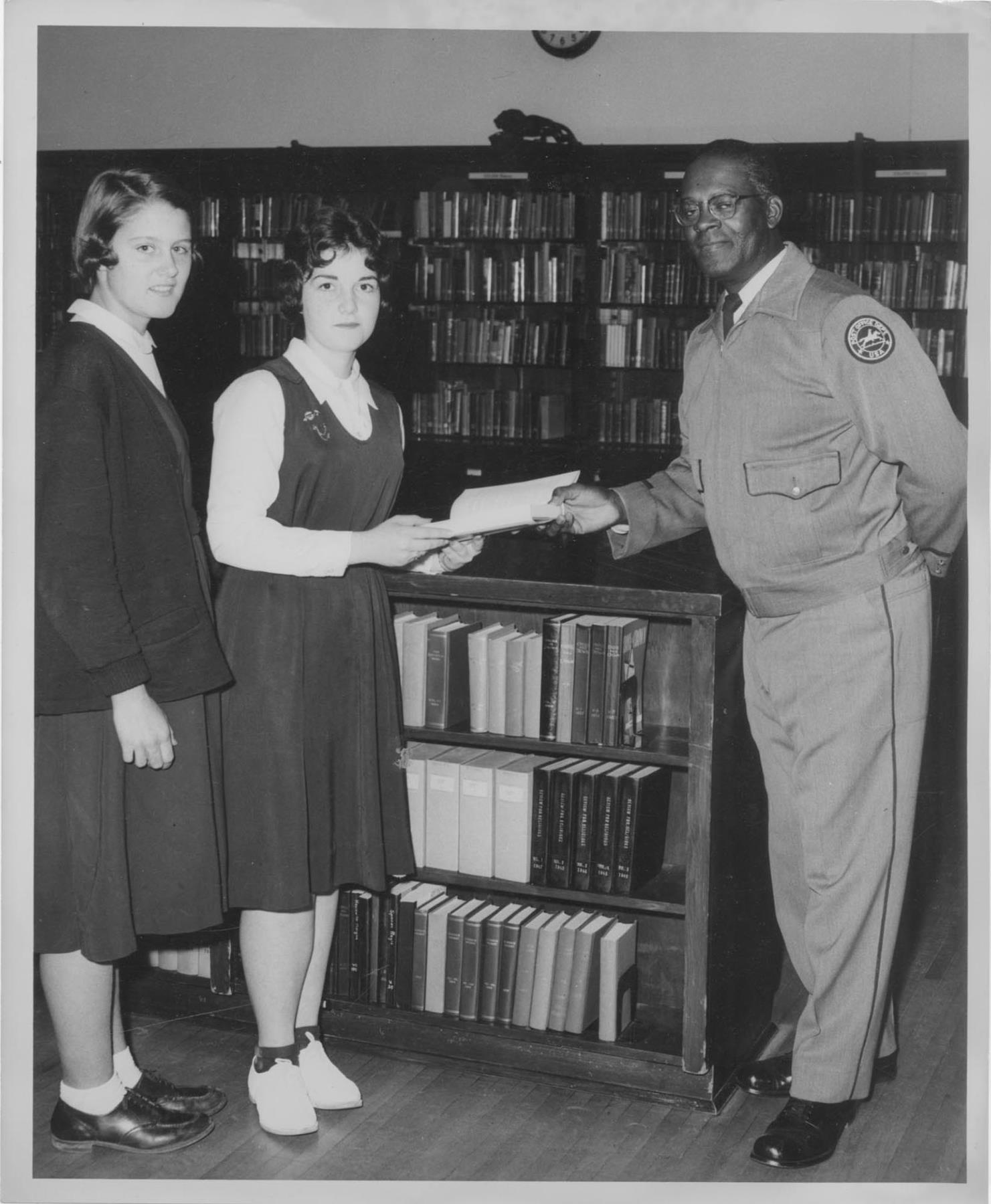 Image of Two young women students with a Post Office Department staff member, Seattle, circa 1956