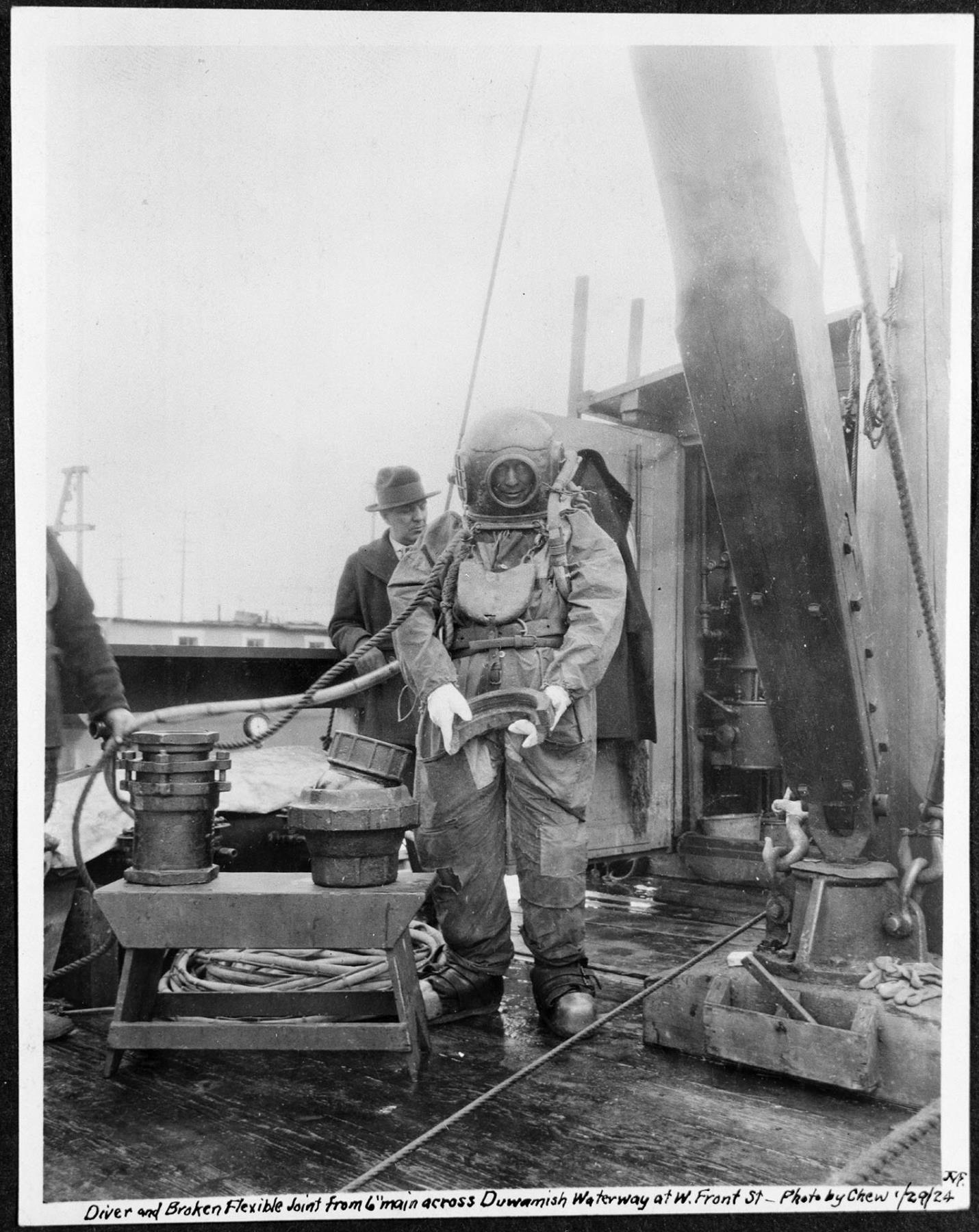 Image of Diver holding a water main joint, Seattle, January 29, 1924