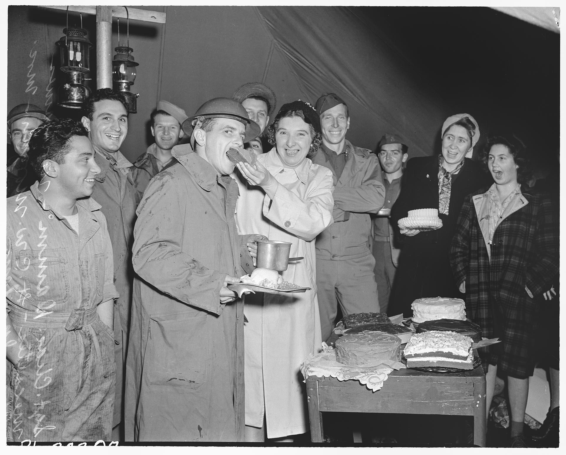 Image of Woman feeding cake to serviceman, Seattle, December 1941