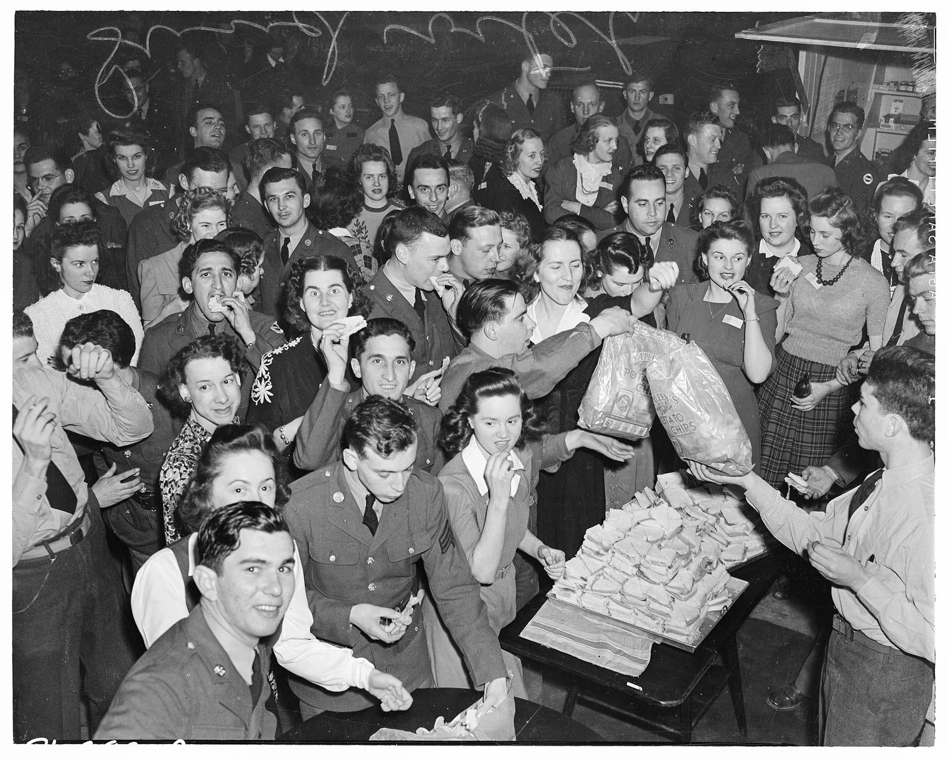 Image of Women and servicemen eating sandwiches at USO club, Seattle, February 1942