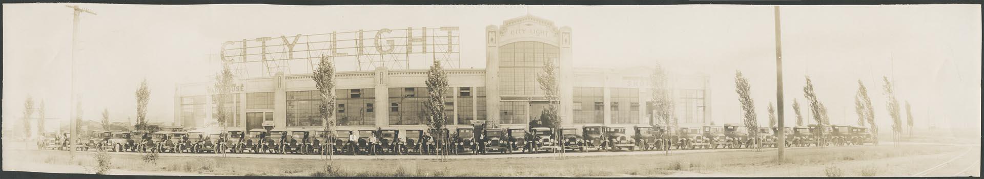 Image of Seattle City Light employees with vehicles in front of warehouse, Seattle, circa 1928