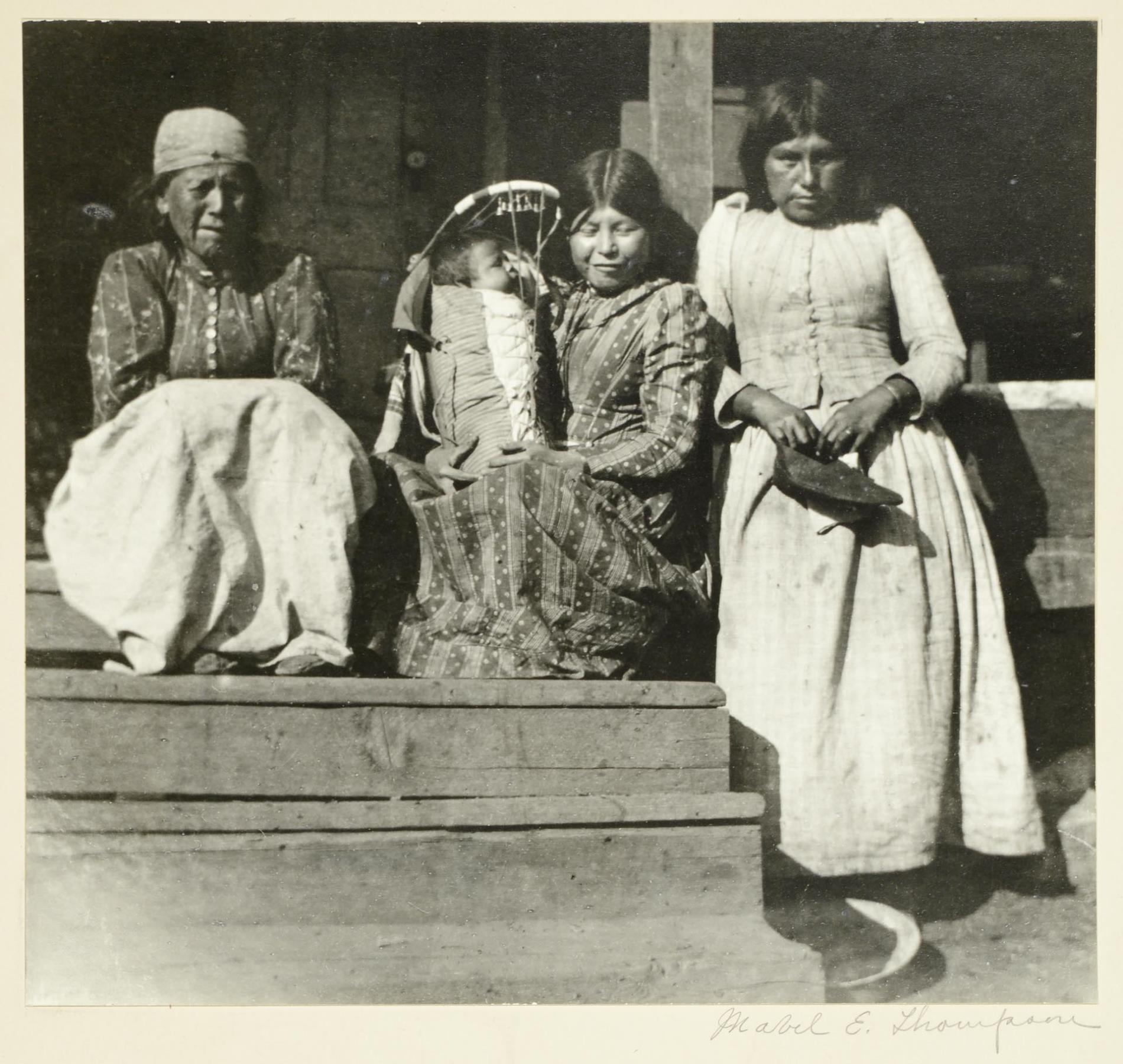 Image of Indigenous women and infant on porch, circa 1900