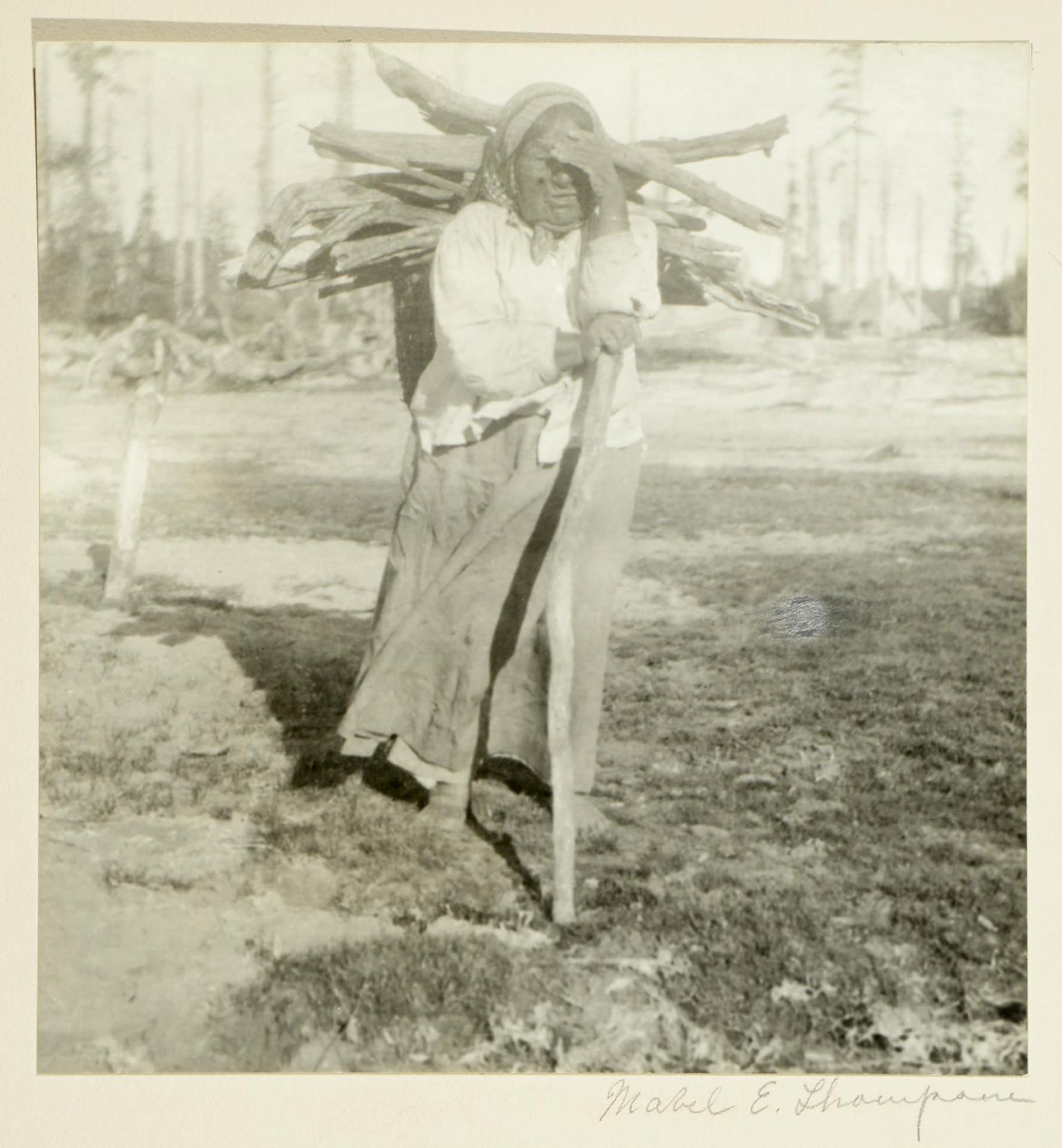 Image of Indigenous woman carrying firewood, circa 1900