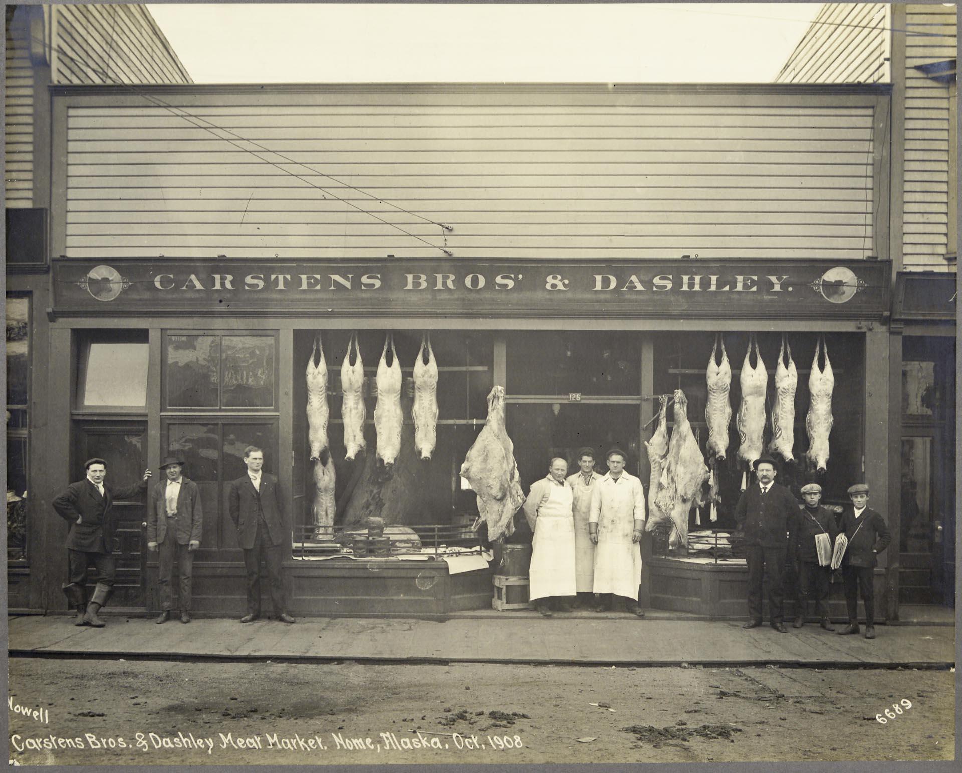 Image of Carstens Bros & Dashley Meat Market employees outside store, Nome, October 1908