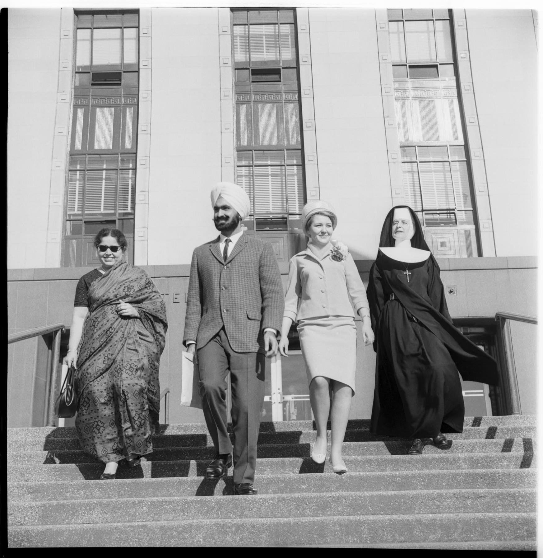Image of Four people leaving courthouse after naturalization ceremony, March 1, 1965
