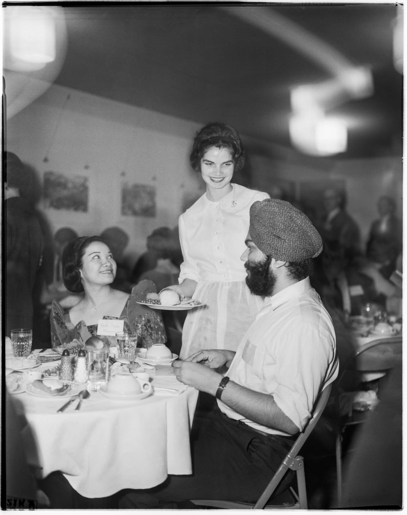 Image of Woman serving dessert to international students, November 1962