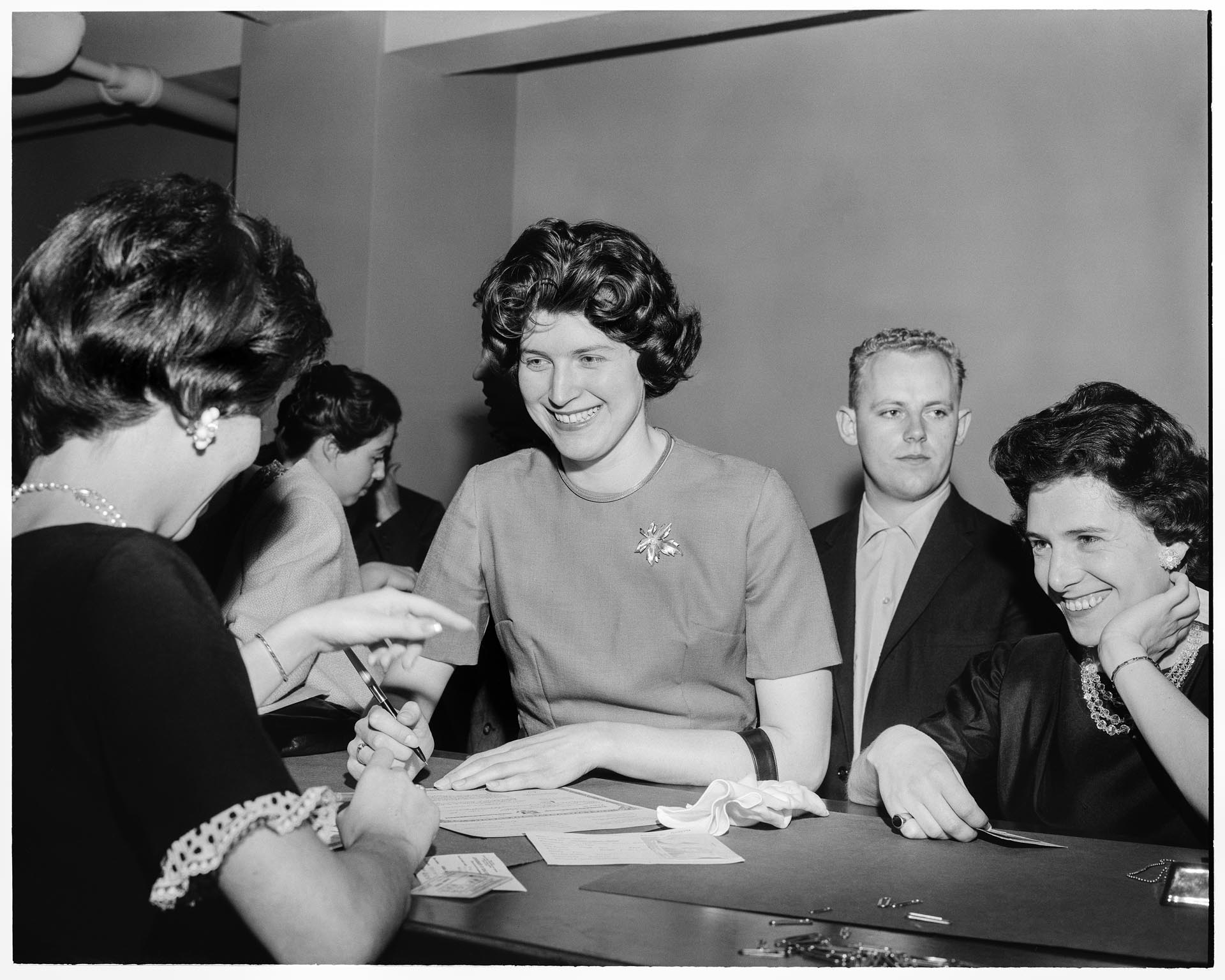 Image of Suzie Ordogh signing naturalization papers inside courthouse, Seattle, April 23, 1962