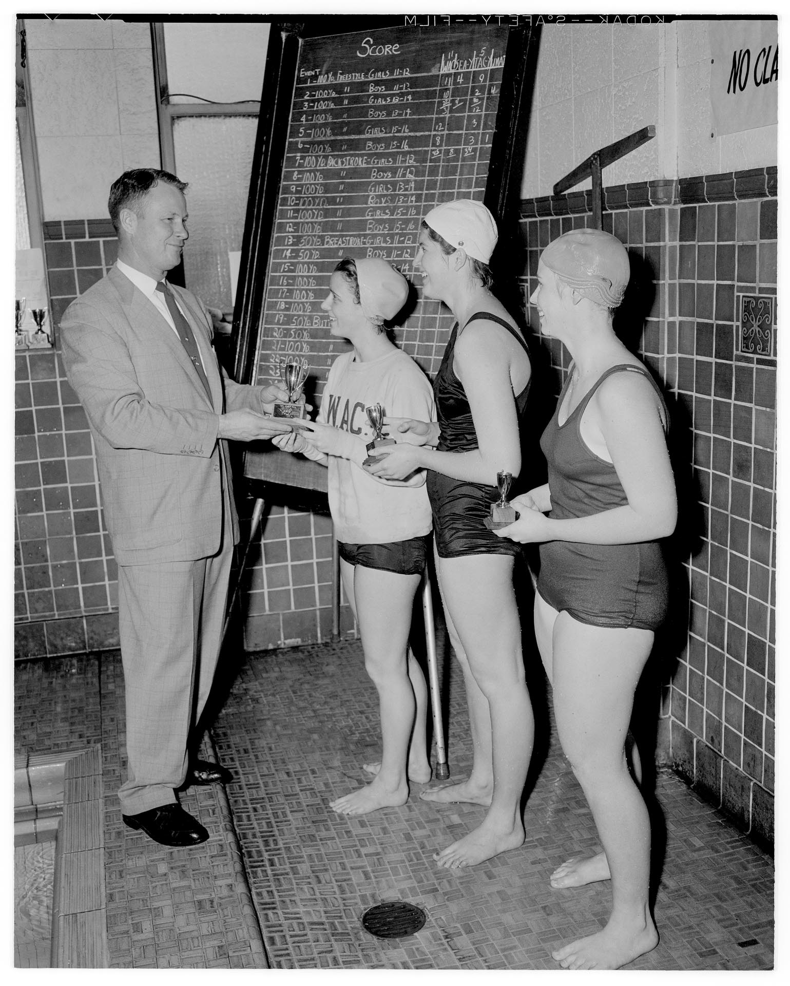 Image of Nancy Ramey receiving trophy at WAC swim meet, Seattle, March 1957