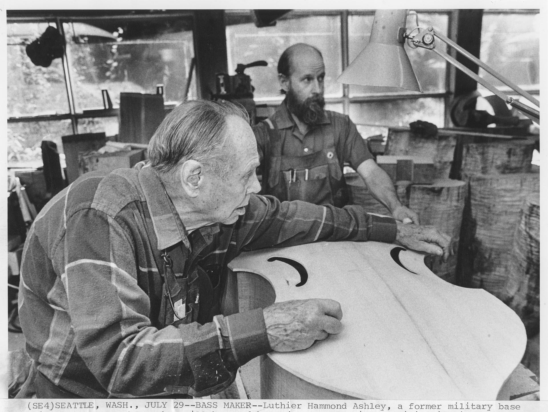 Image of Hammond Ashley and Dave Wilson working on a bass in their workshop, Seattle, July 18, 1989