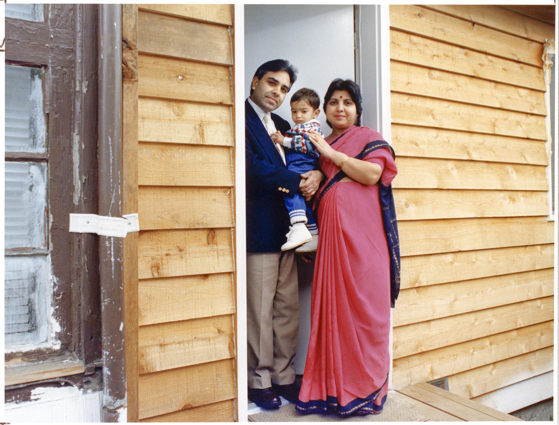 Image of Harish Bharti and family in doorway of their home, May 24, 1990