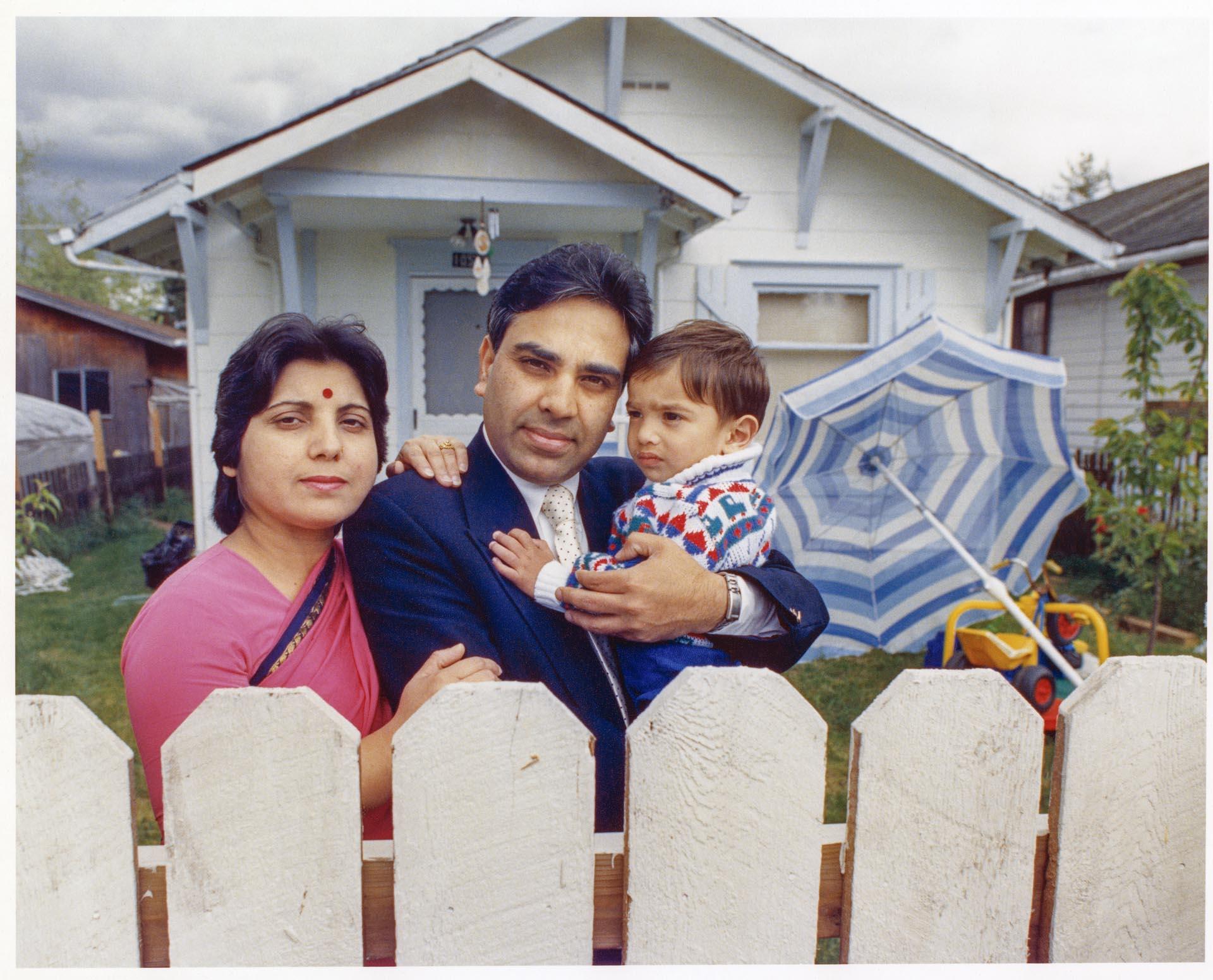 Image of Harish Bharti and family in front of their home, May 24, 1990