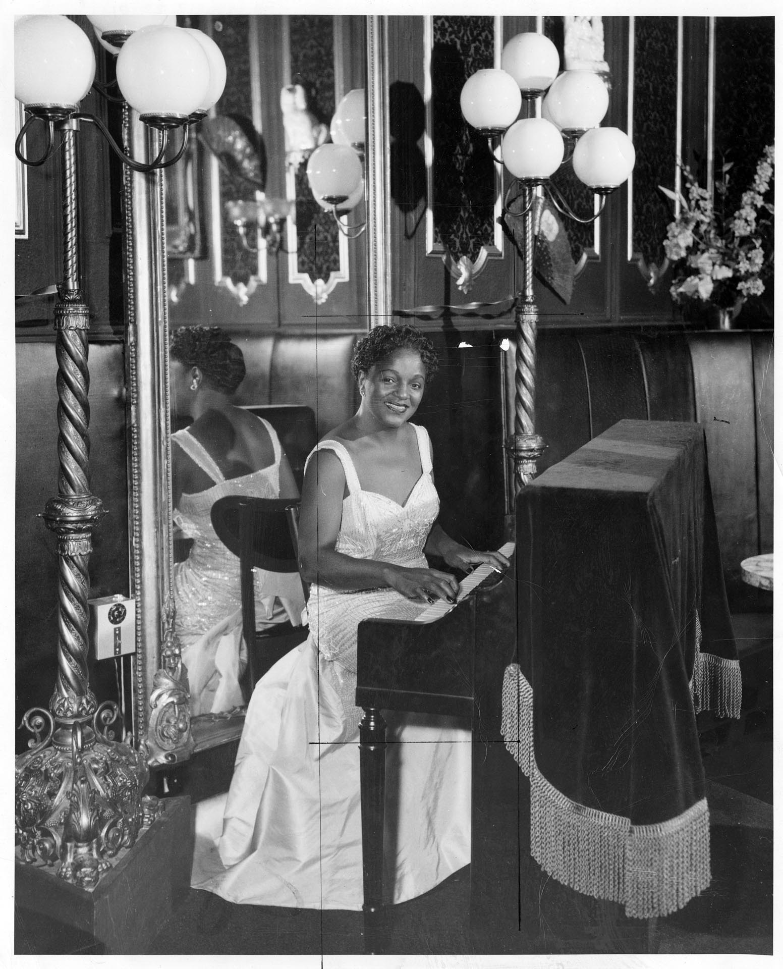 Image of Ruby Bishop posing at piano at Ivar's Restaurant, Seattle, February 2, 1958