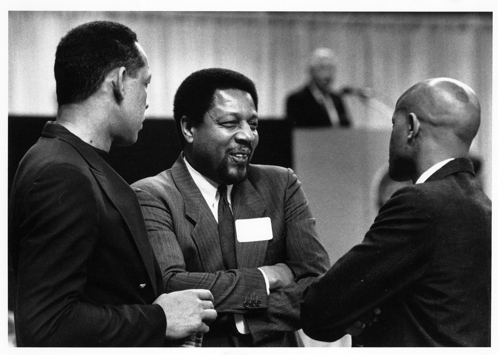 Image of John Johnson, Fred Brown, and Slick Watts talking together at Kingdome event, Seattle March 27, 1991