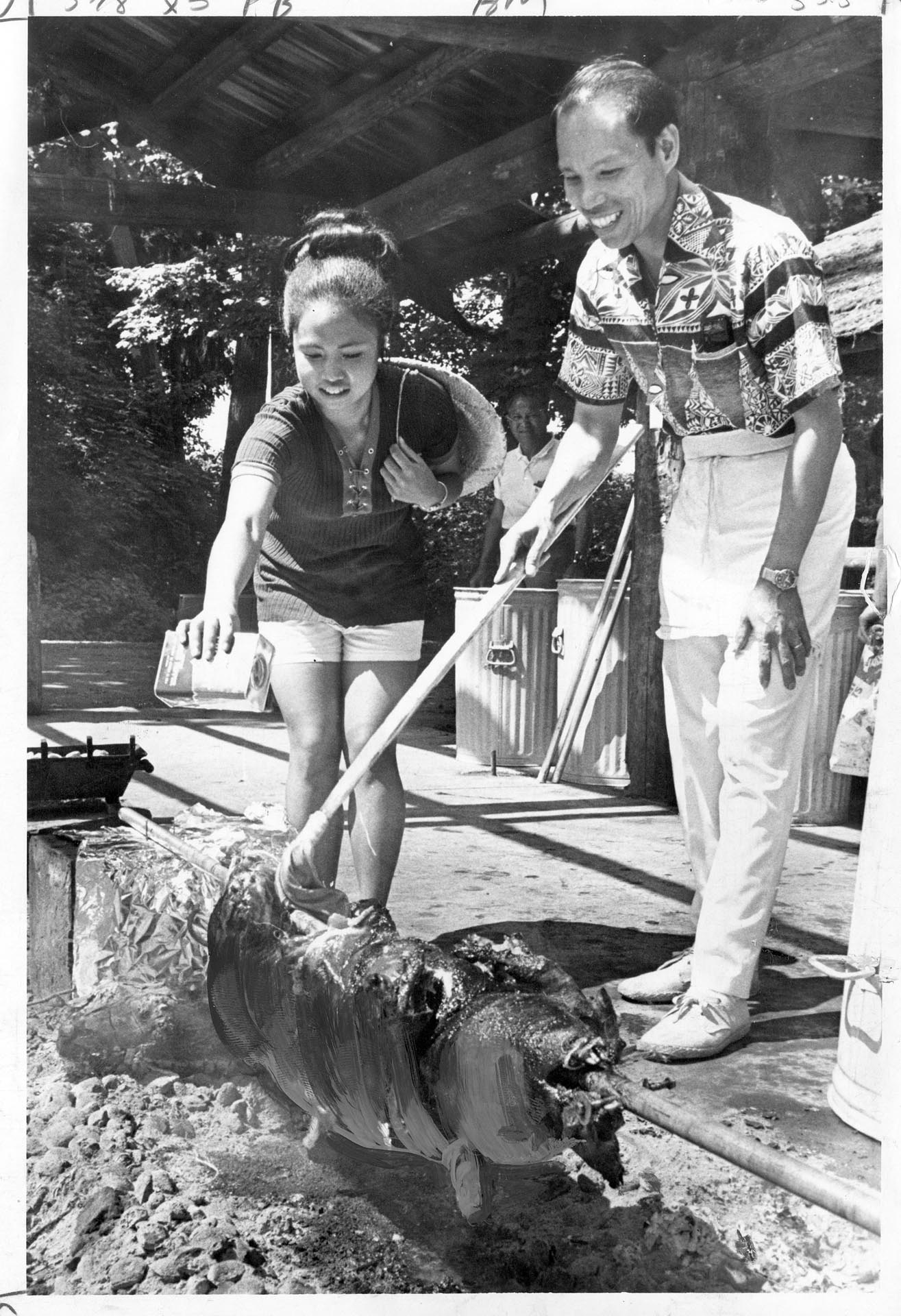 Image of Barbara Bergano and Lope Malle roasting a pig at Seafair Fiesta Filipina, Seattle, August 7, 1971