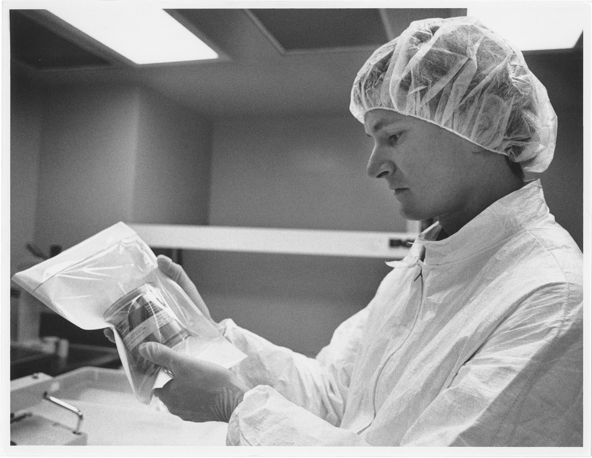 Image of Product technician inspecting package at IMRE Corporation lab, Seattle, March 1, 1993