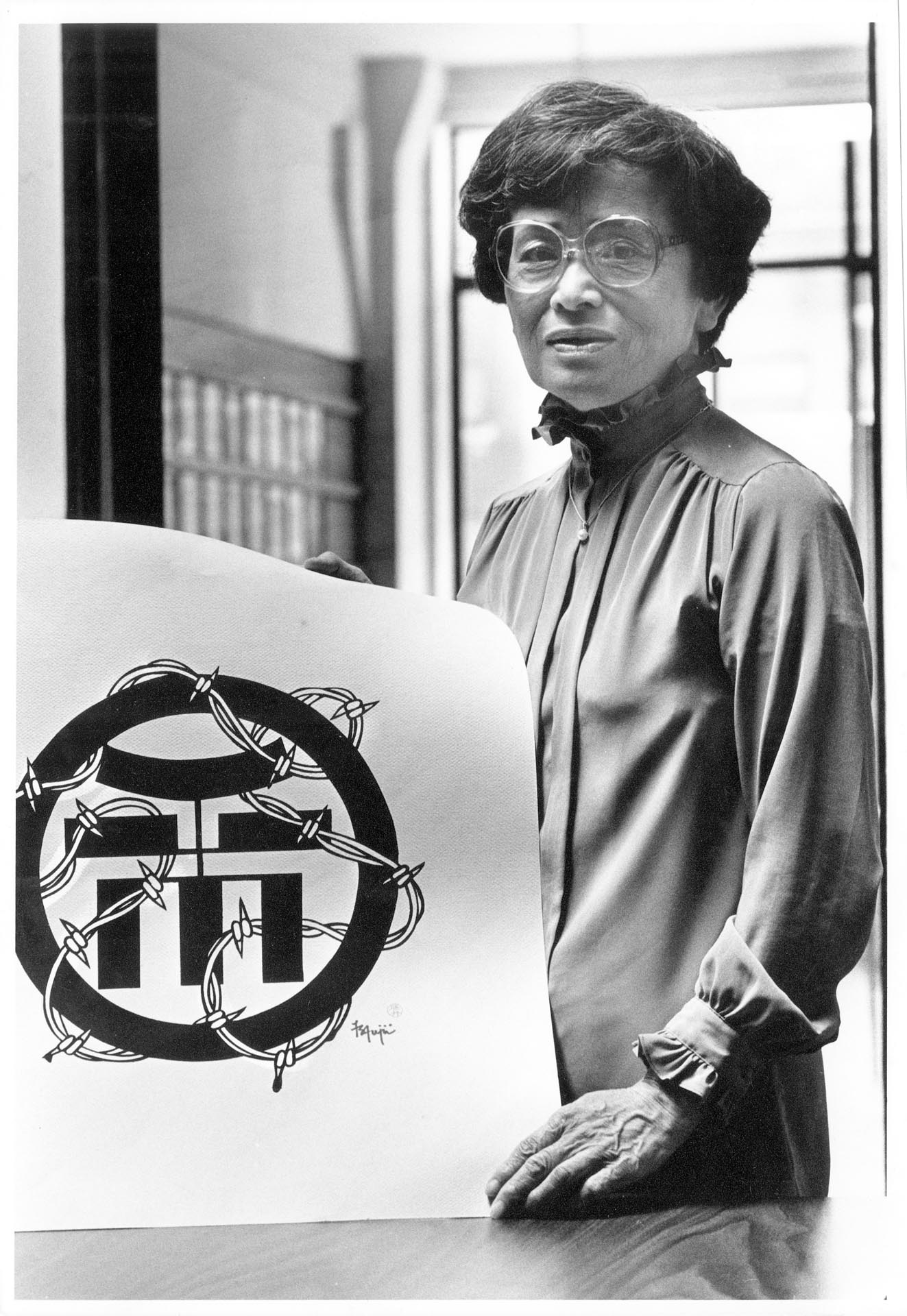 Image of Cherry Kinoshita holding symbol of Japanese American incarceration, Seattle, July 22, 1988