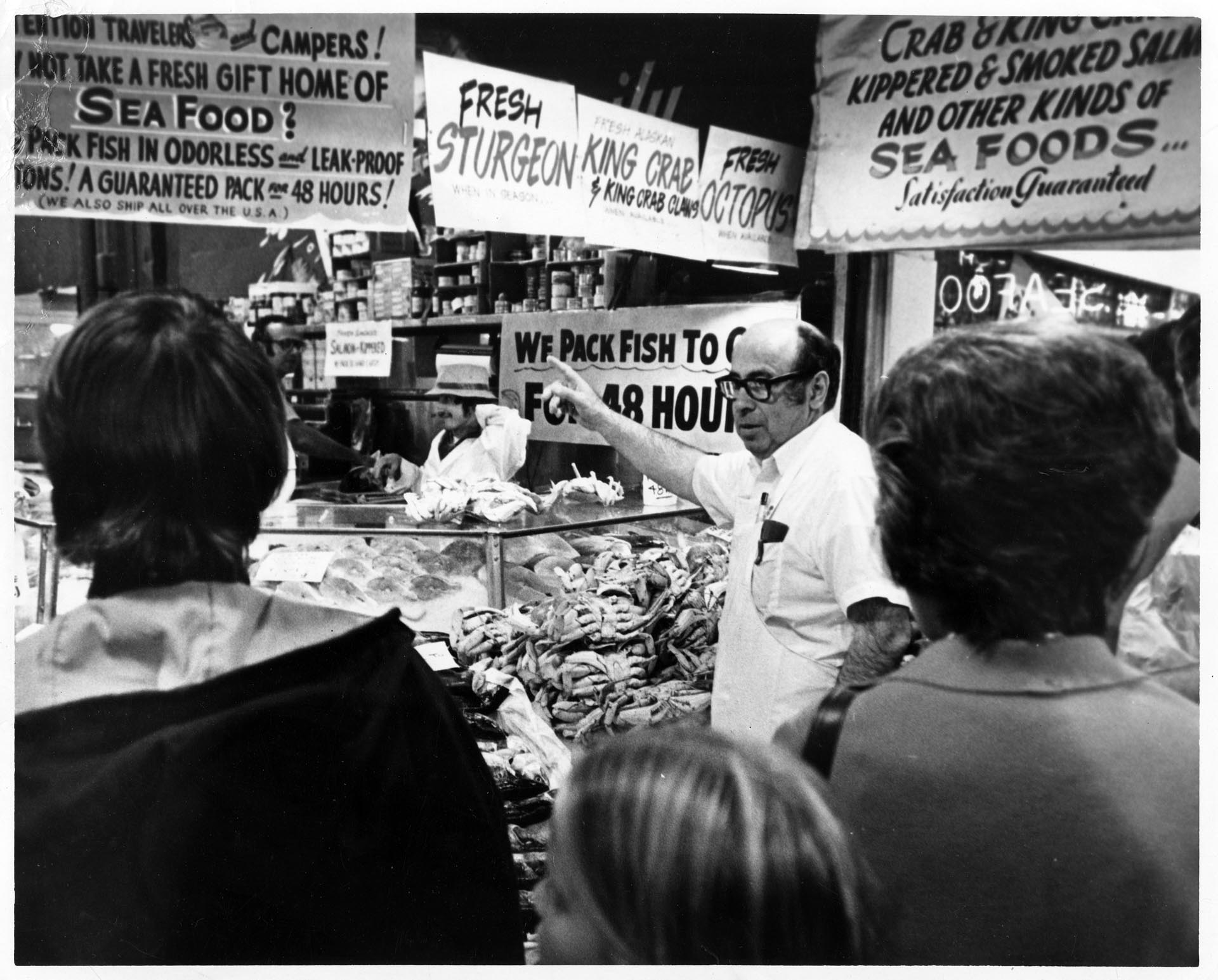 Image of Customers listening to fish monger at Pike Place Fish Market, Seattle, August 6, 1973