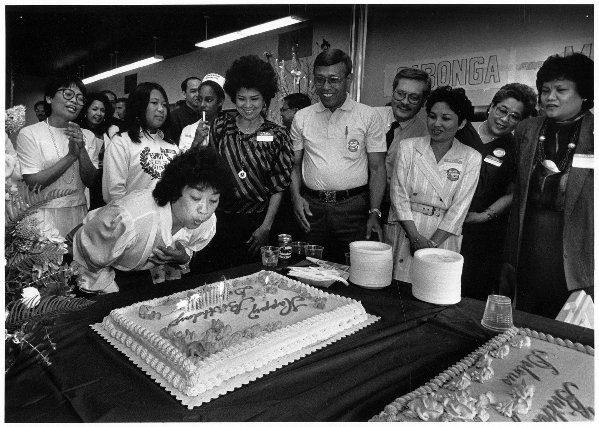 Image of Dolores Sibonga blowing out birthday candles at her campaign offices, Seattle, August 28, 1989
