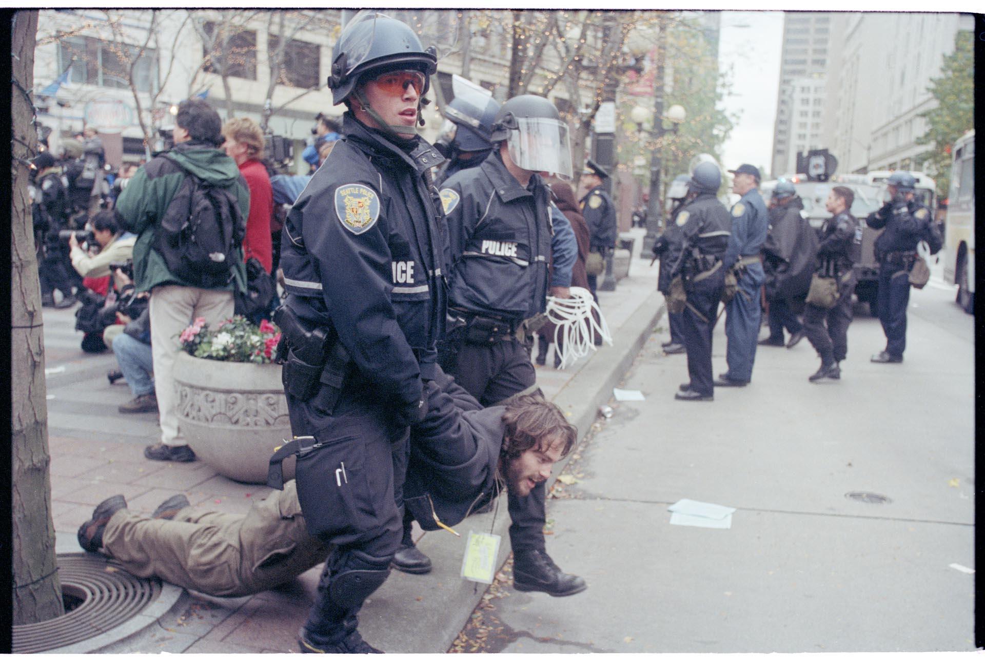 Image of Police officers holding demonstrator at WTO protest, Seattle, December 1, 1999