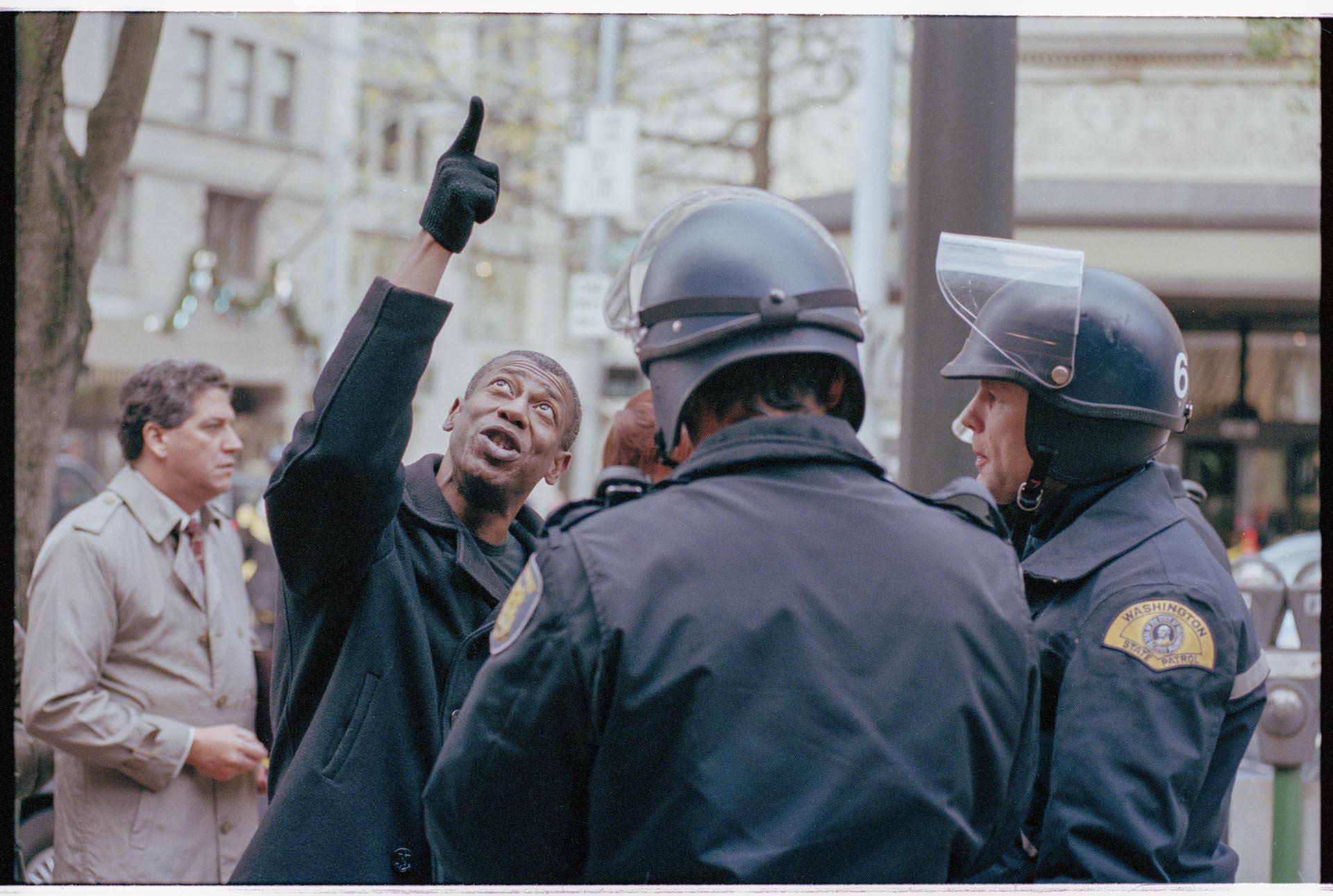 Image of Man speaking with police officers at WTO protest, Seattle, December 3, 1999