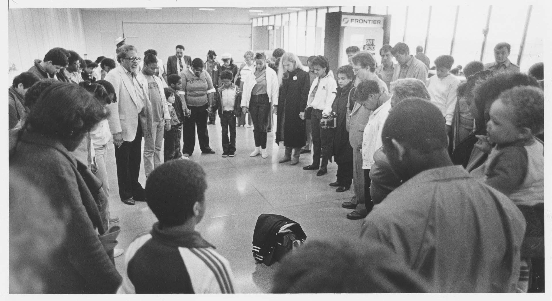 Image of Total Experience Gospel Choir praying together at Sea-Tac airport, January 23, 1986