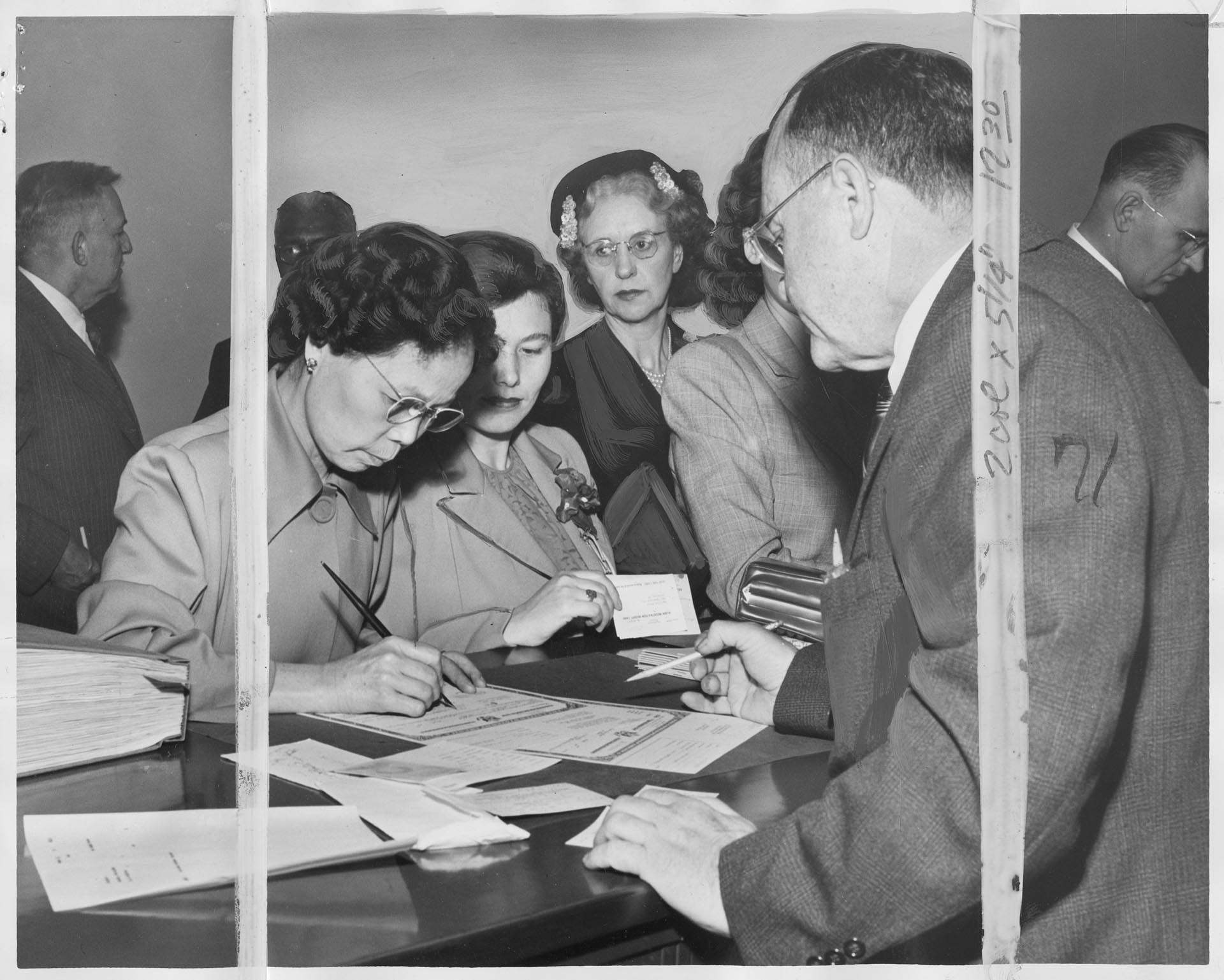 Image of Jung Oy Chinn signing U.S. naturalization papers, Seattle, September 17, 1951