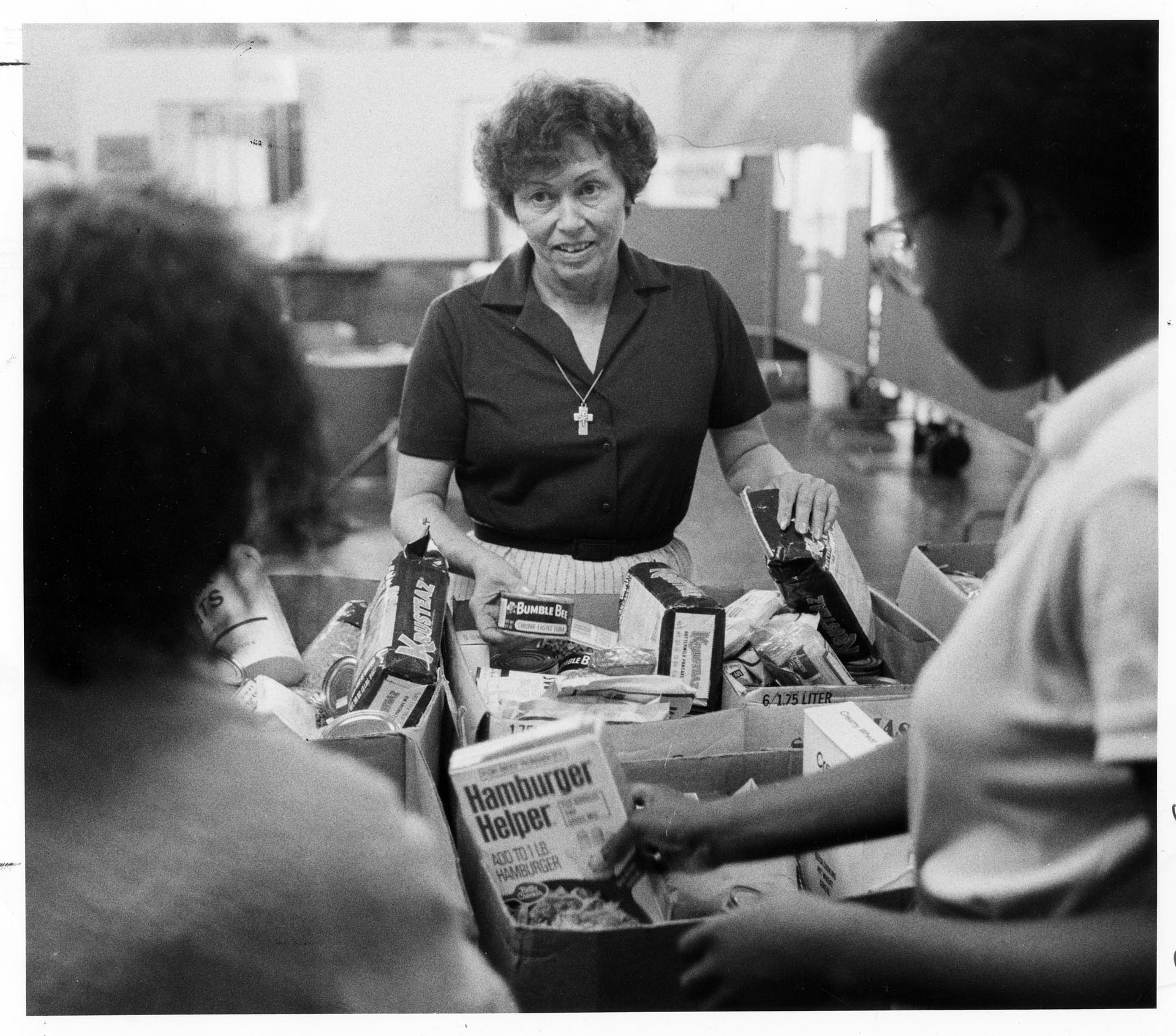 Image of Ruth Velozo sorting food with volunteers at Northwest Second Harvest, Seattle, August 3, 1983