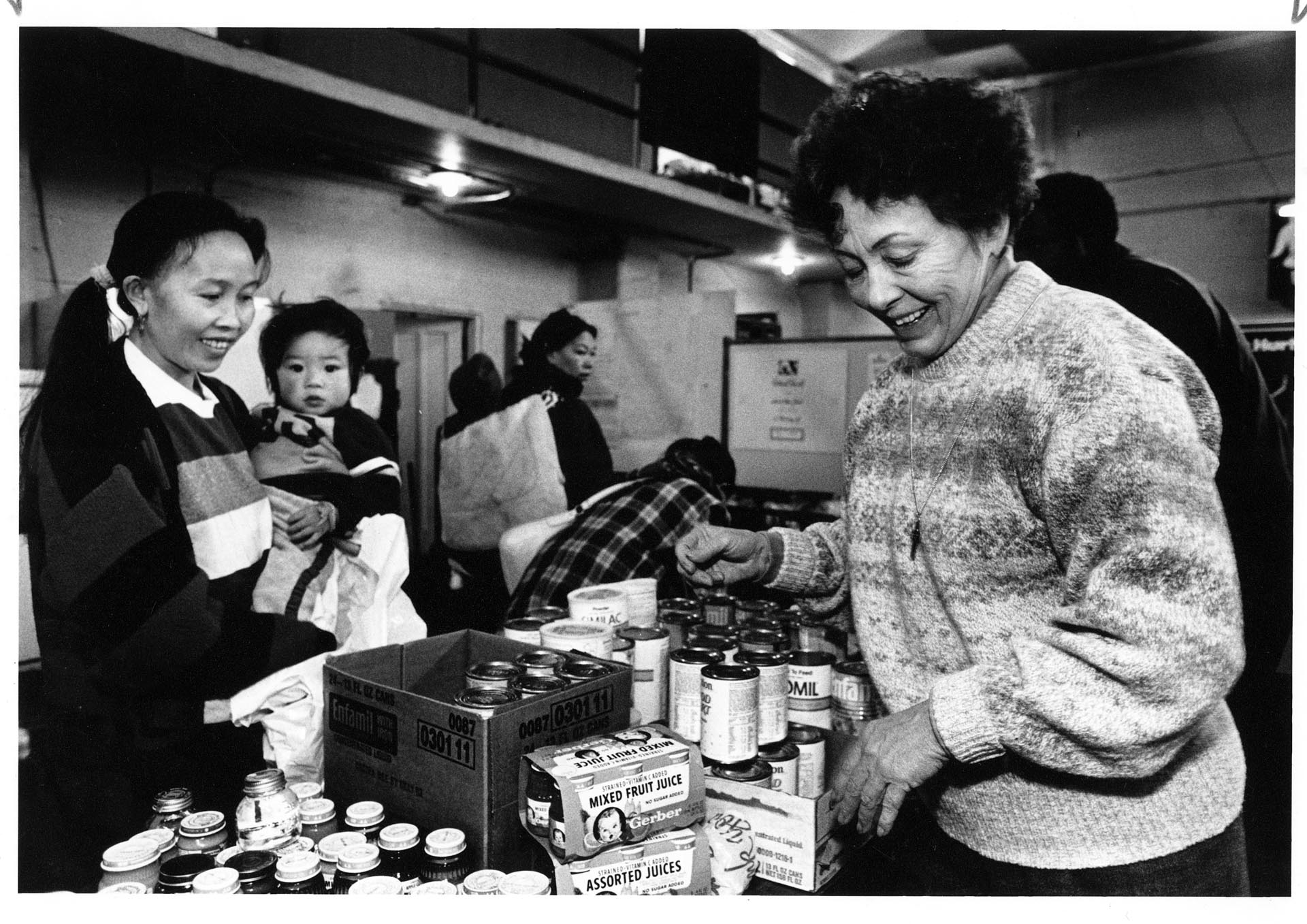 Image of Kuuseng Sateurn and Lai Sio receiving goods from Ruth Velozo at Northwest Harvest, Seattle, December 27, 1990