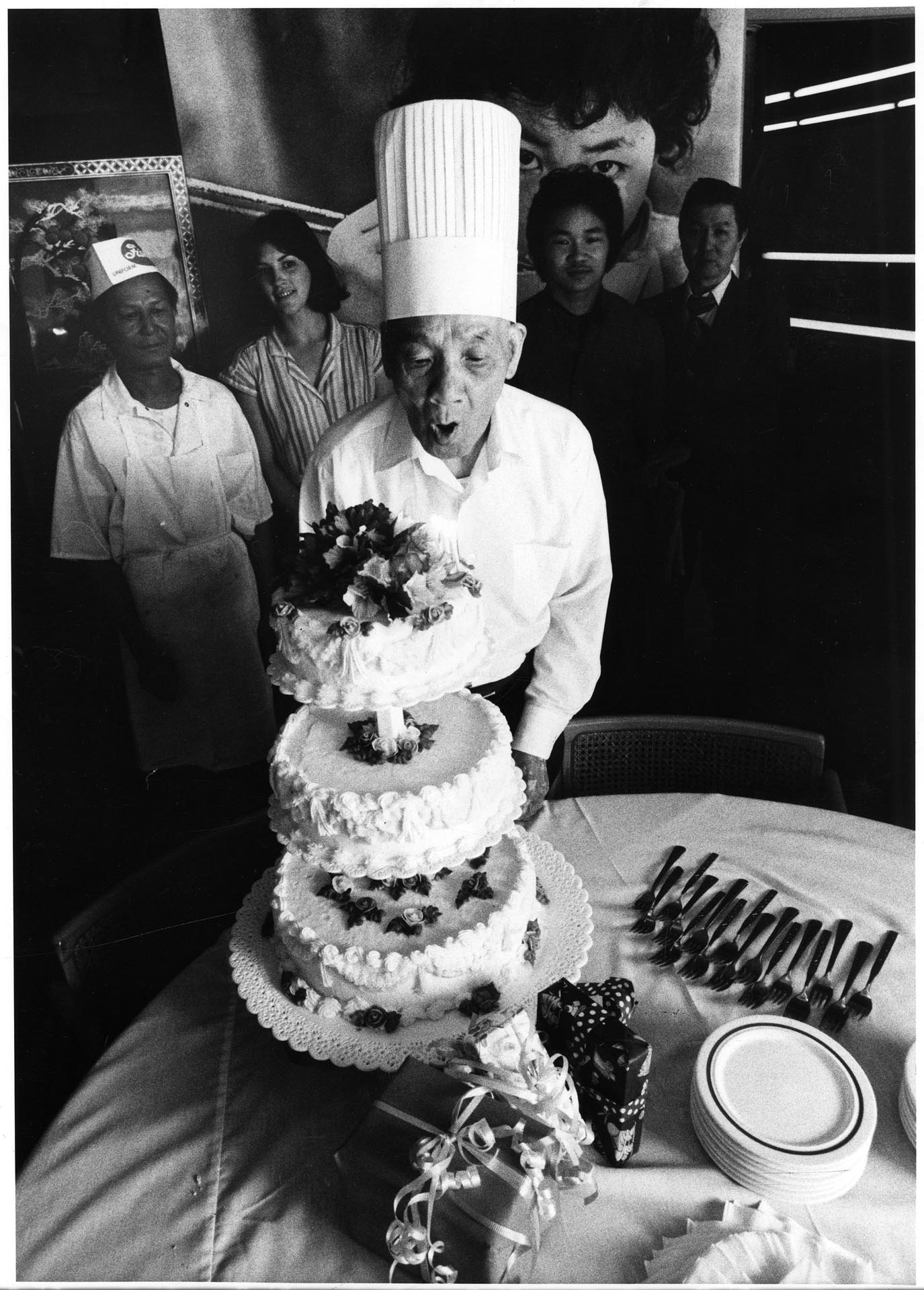 Image of Henry Woo blowing out birthday candles at Linyen Restaurant & Lounge, Seattle, July 11, 1982