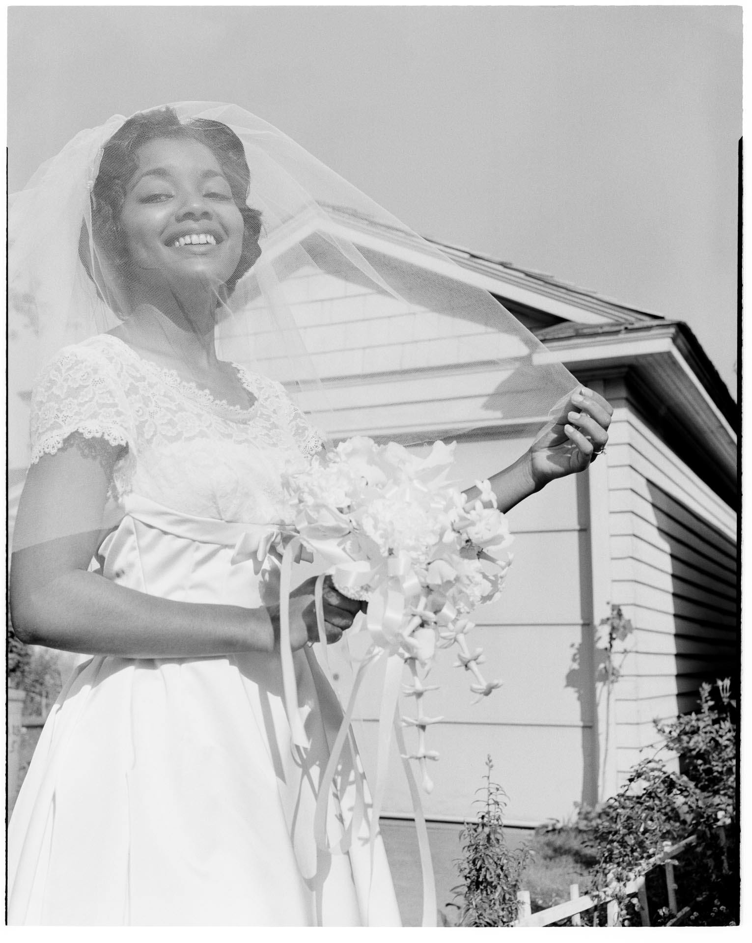 Image of Woman in wedding dress outside a house, Seattle, circa 1955