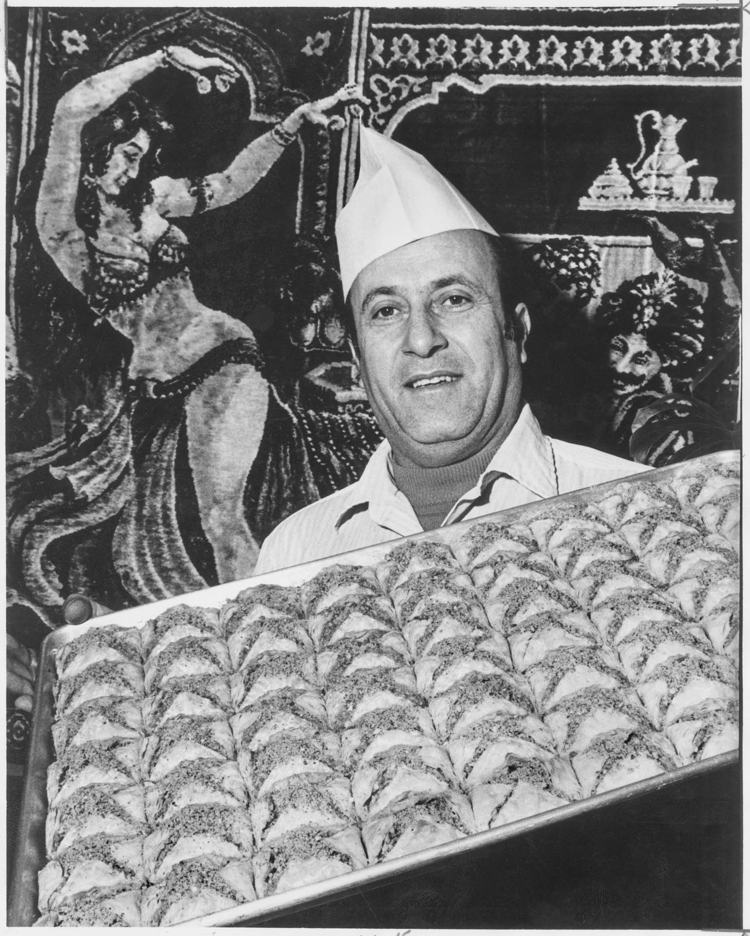 Image of Anwar Aboul Hosn with tray of baklava, December 1977