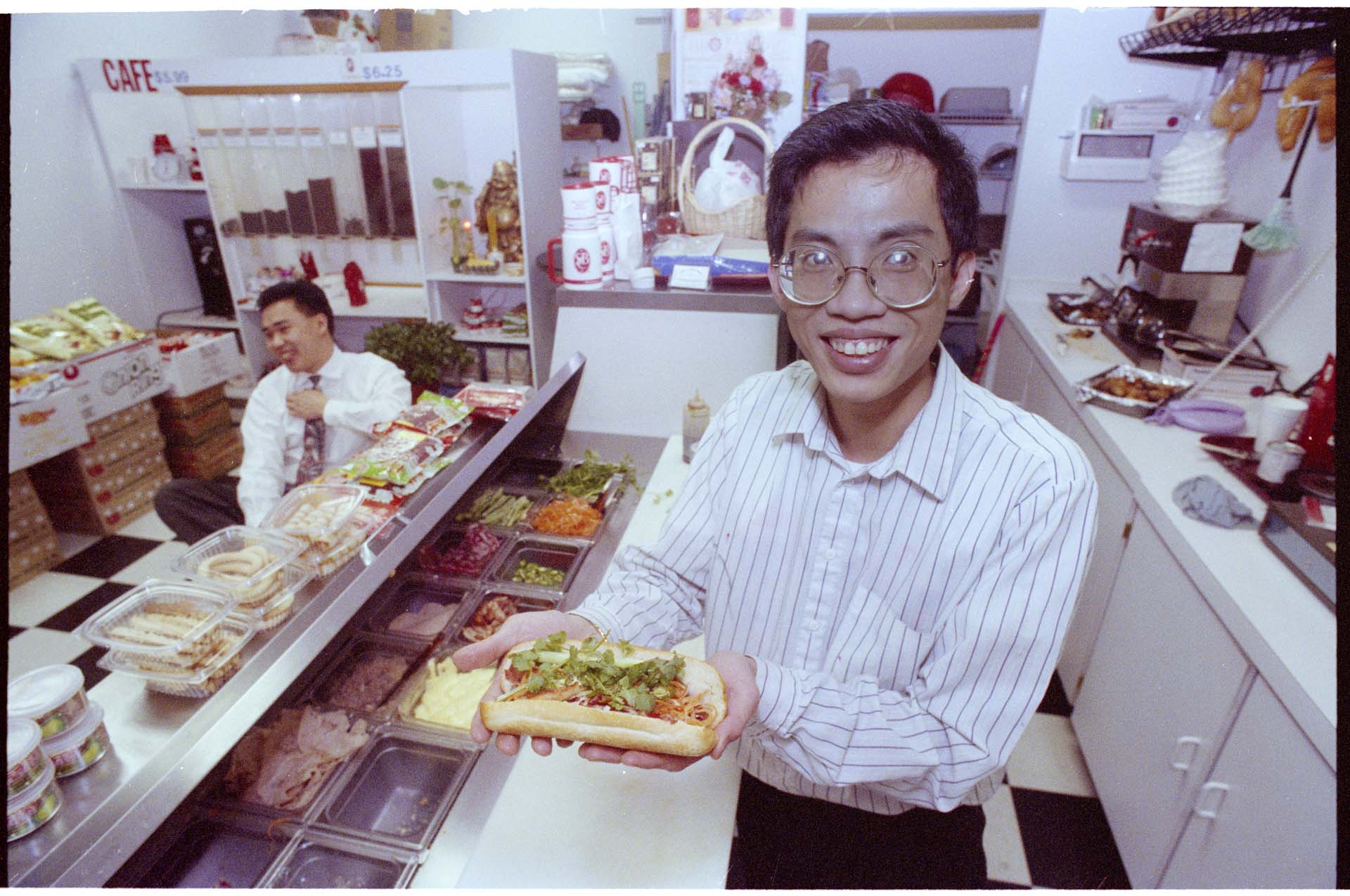 Image of Counterman with banh mi sandwich at Vietnamese deli, Seattle, January 14,1993