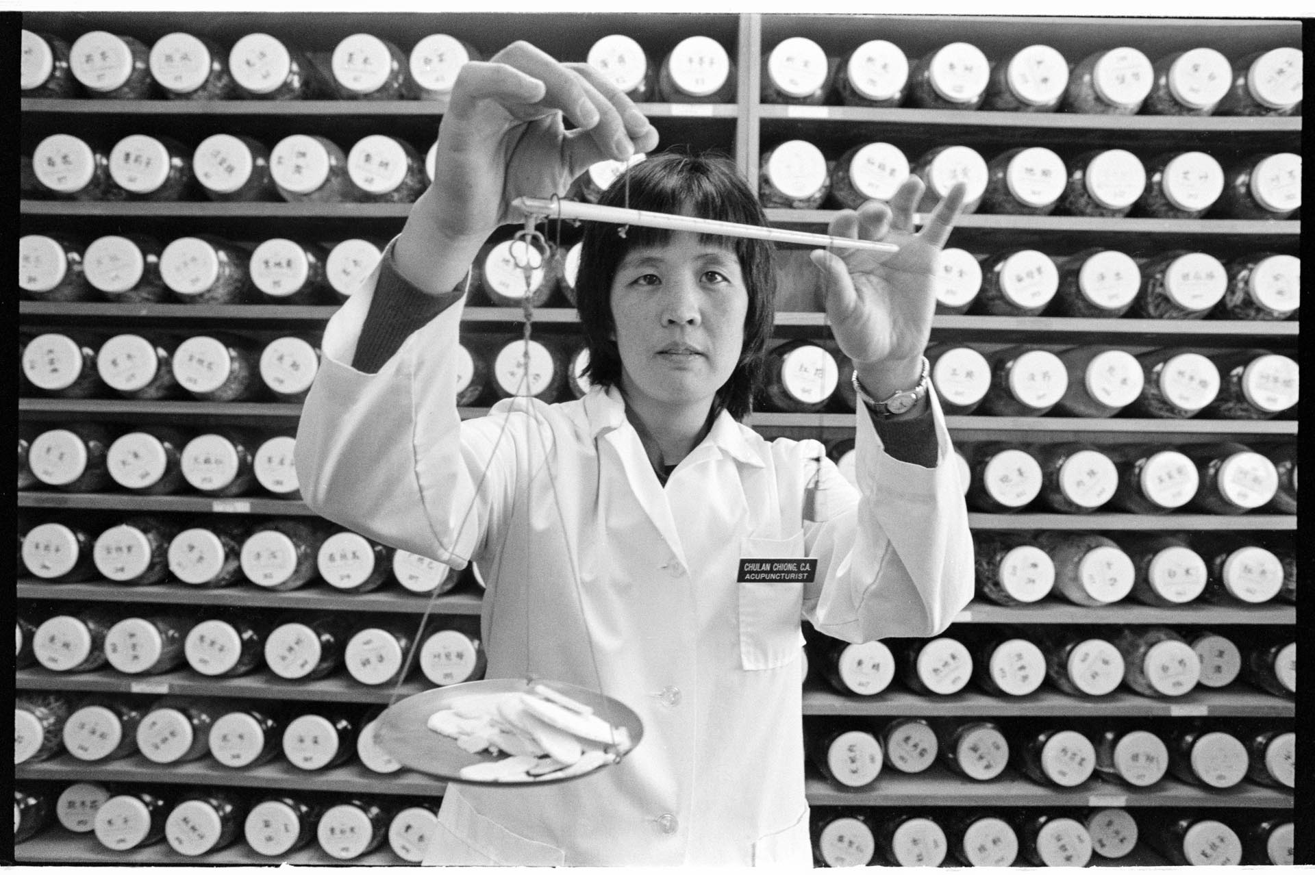 Image of Chu-Lan Chiong weighing medicinal herbs, Seattle, March 1, 1993