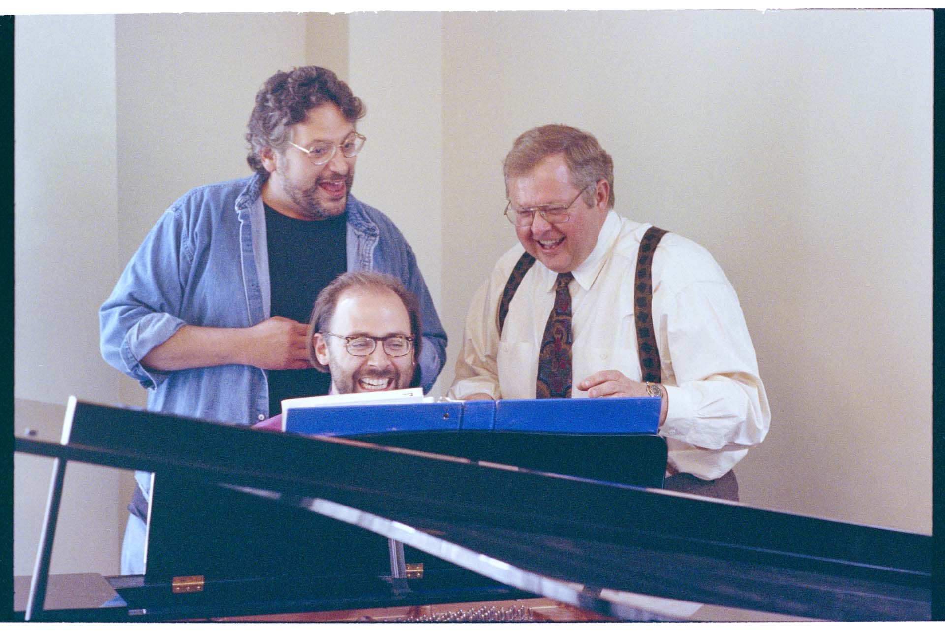 Image of Harvey Fierstein, Evan Stults, and Dennis Coleman around piano, Seattle, June 22, 1993