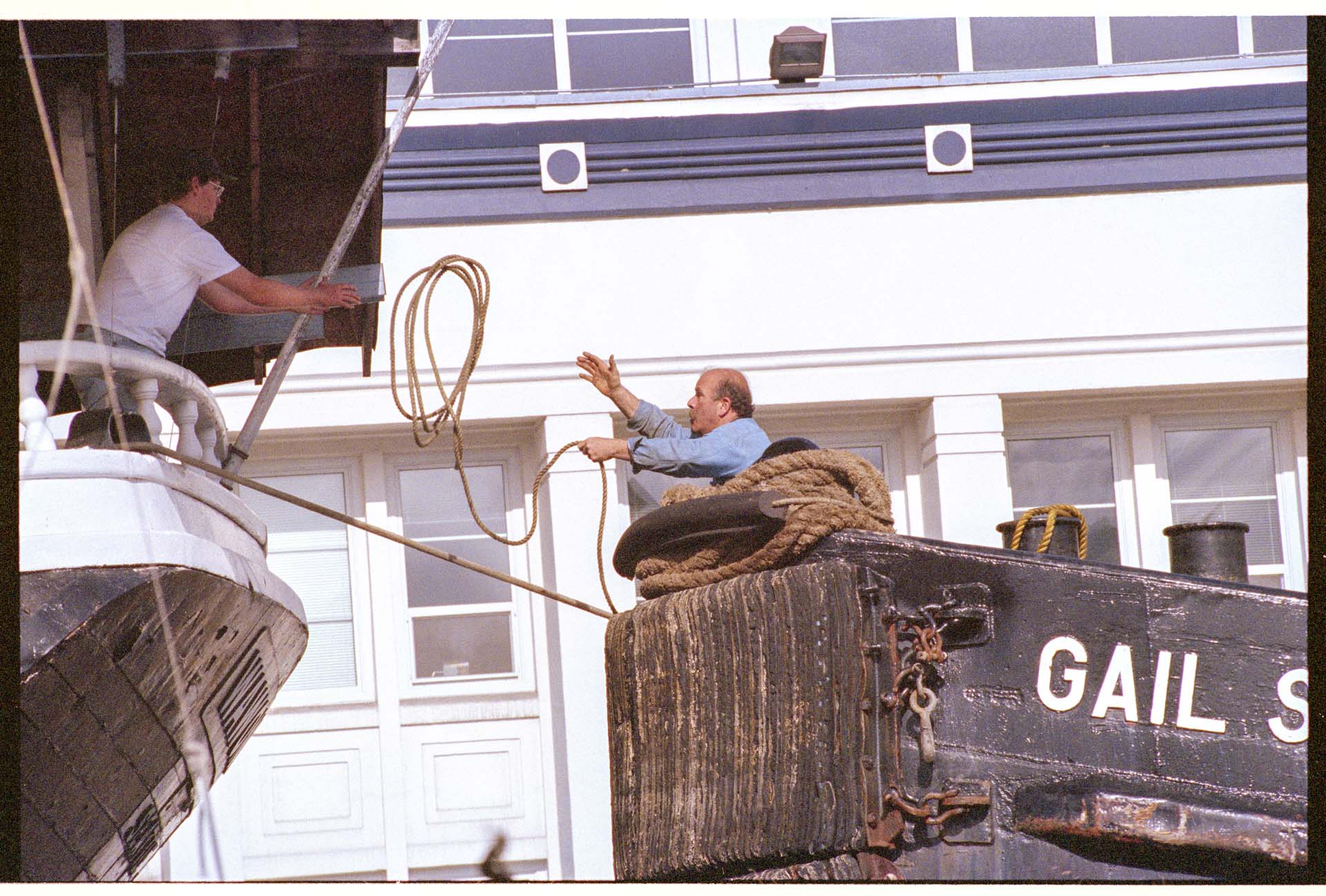 Image of Man on tug Gail S tossing rope to man on the Wawona, June 23, 1993