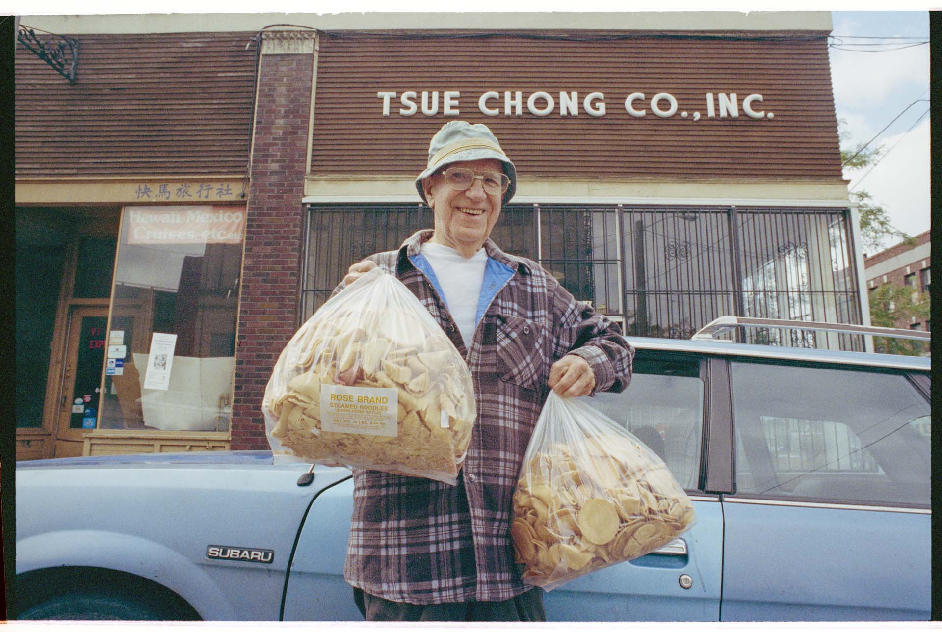 Image of Customer with bags of fortune cookie wafers outside Tsue Chong Co., Seattle, July 18, 1993
