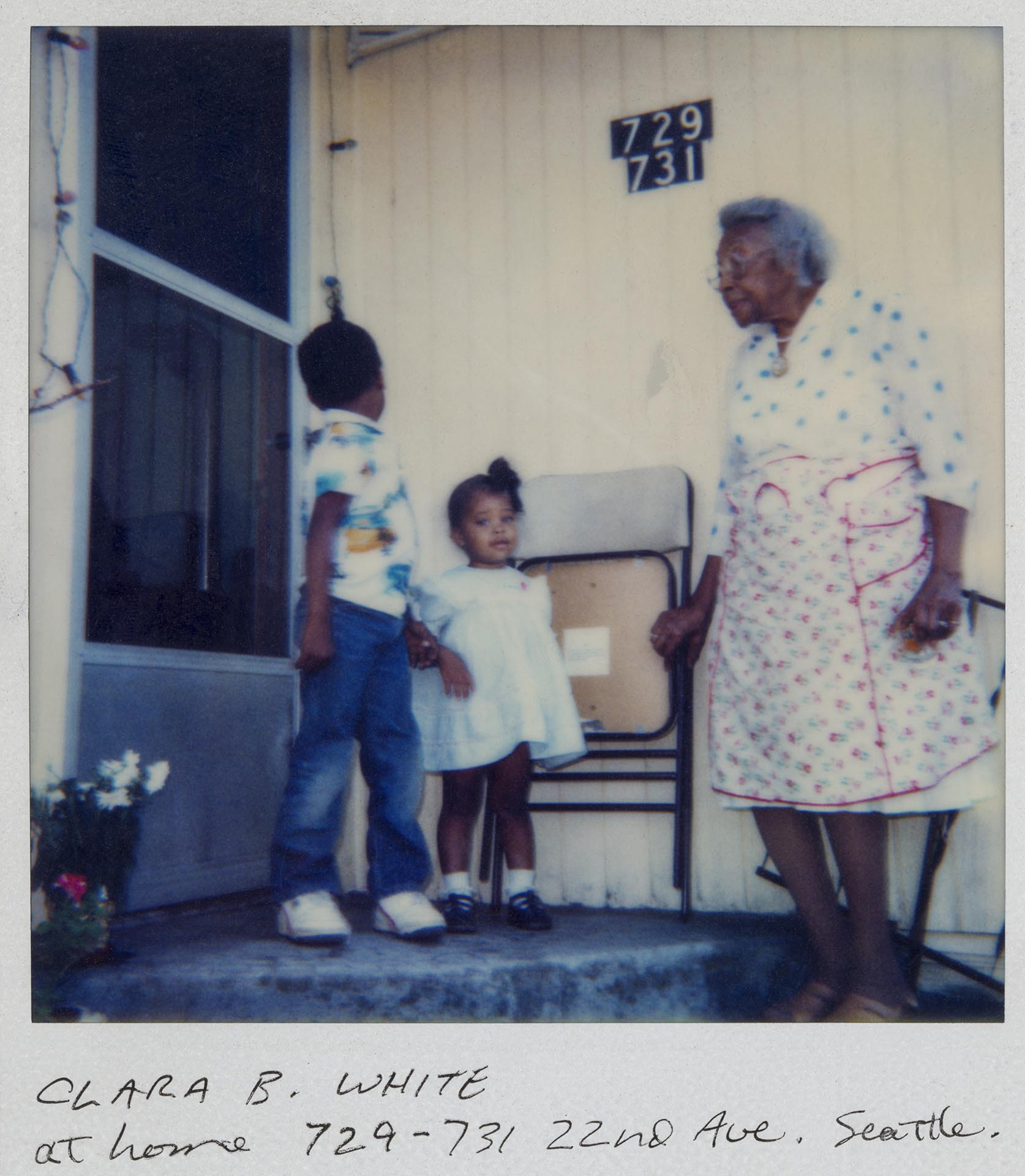 Image of Clara B. White and two children on porch of house, Seattle, circa 1975