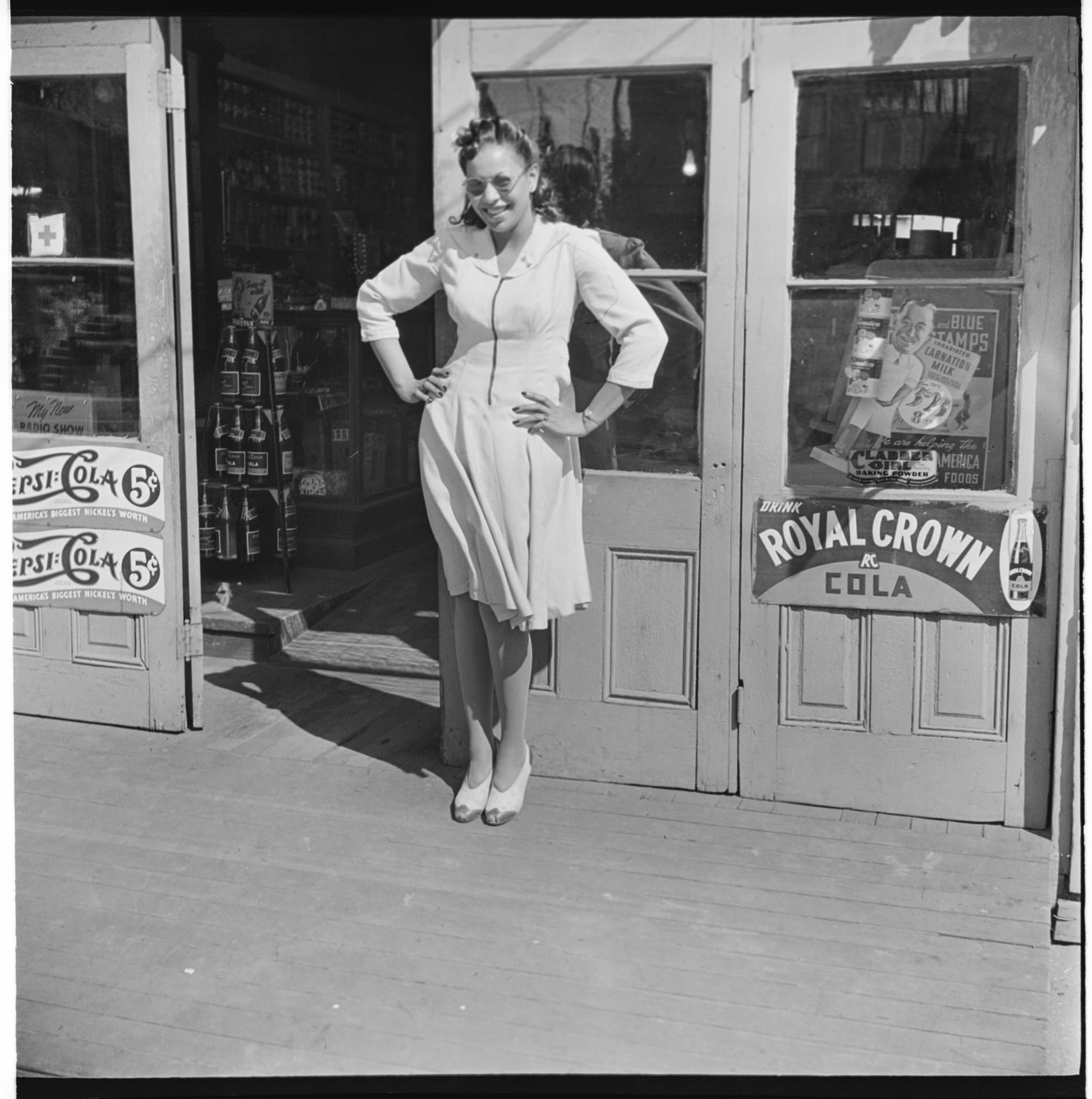 Image of Woman posing in front of grocery store, Seattle, circa 1950