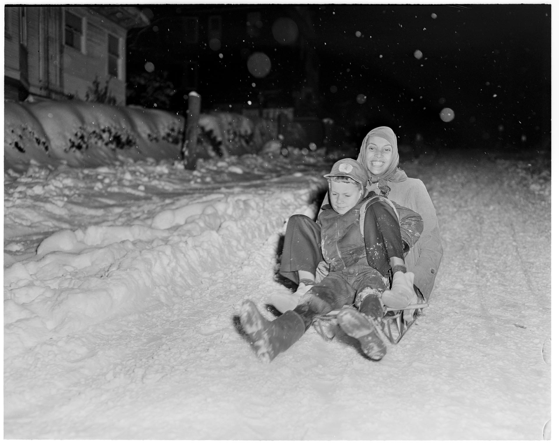 Image of Butch & Izzy Smith riding on a sled, Seattle, circa 1950
