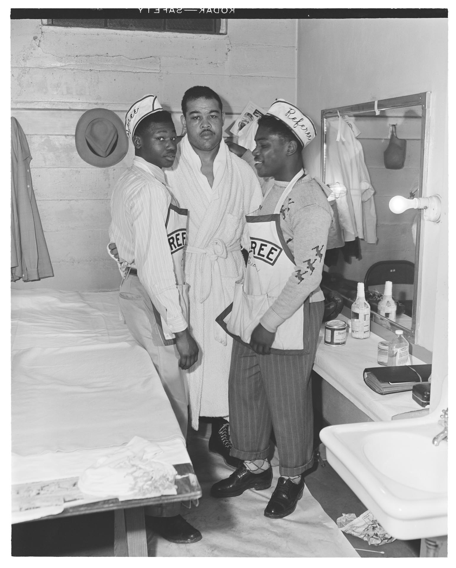 Image of Joe Louis with two young boxers backstage at an exhibition match, Seattle, circa 1950