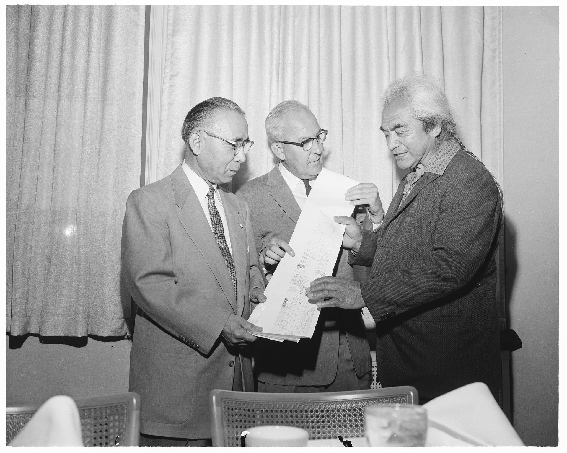 Image of Joseph Hillaire (Kwul-kwul'tw) showing totem pole sketch to William Devin and Genji Mihara, Seattle, June 1961