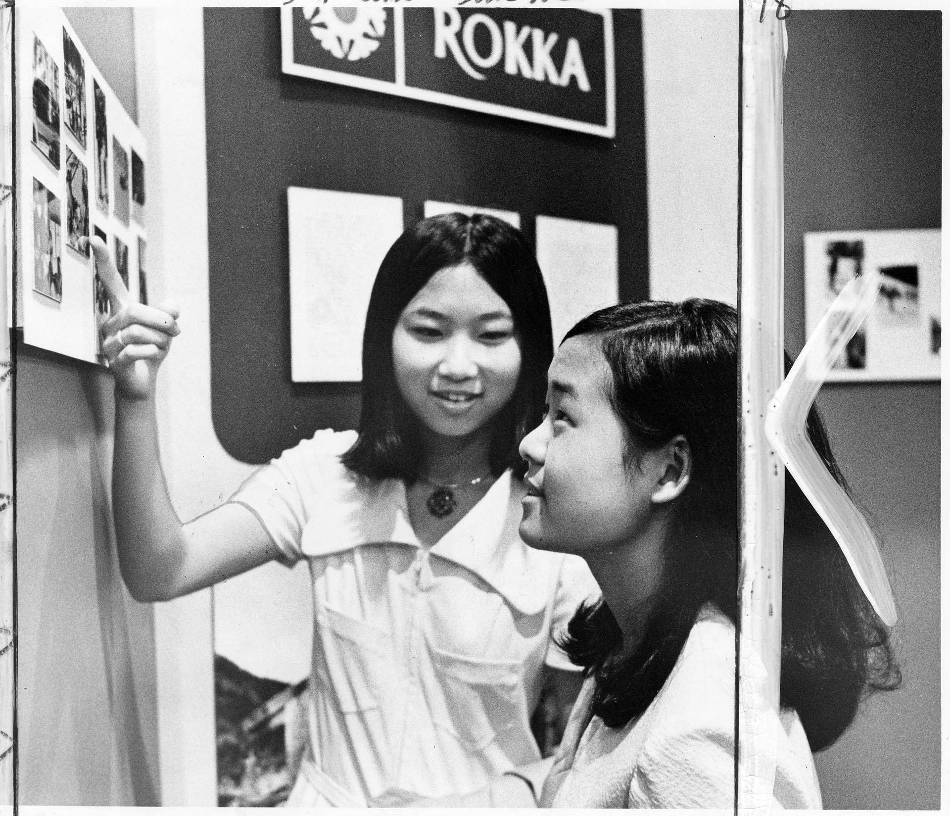Image of Young women looking at photos at 