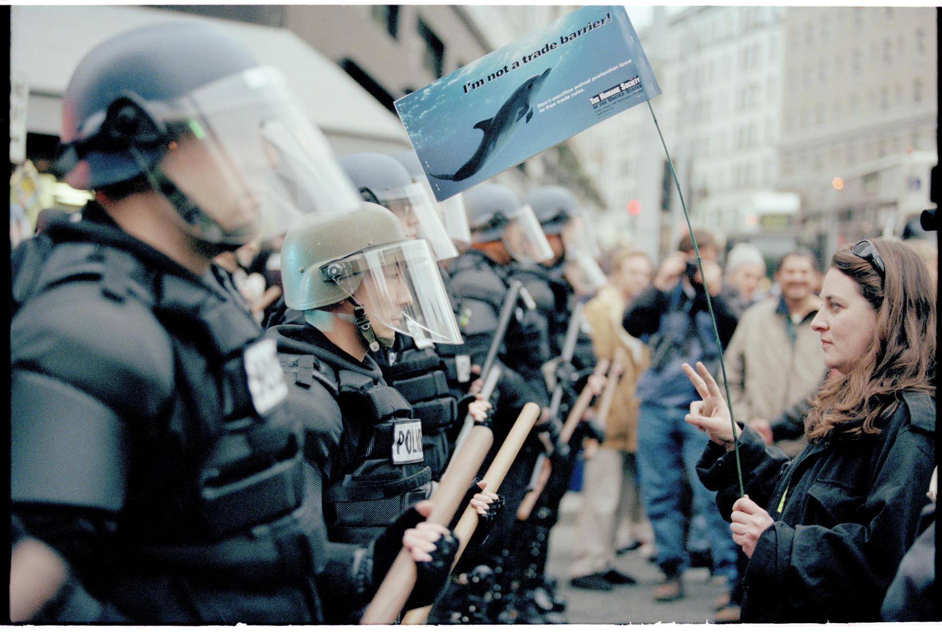 Image of Erin O'Connell facing line of police officers at WTO protest, Seattle, November 29, 1999