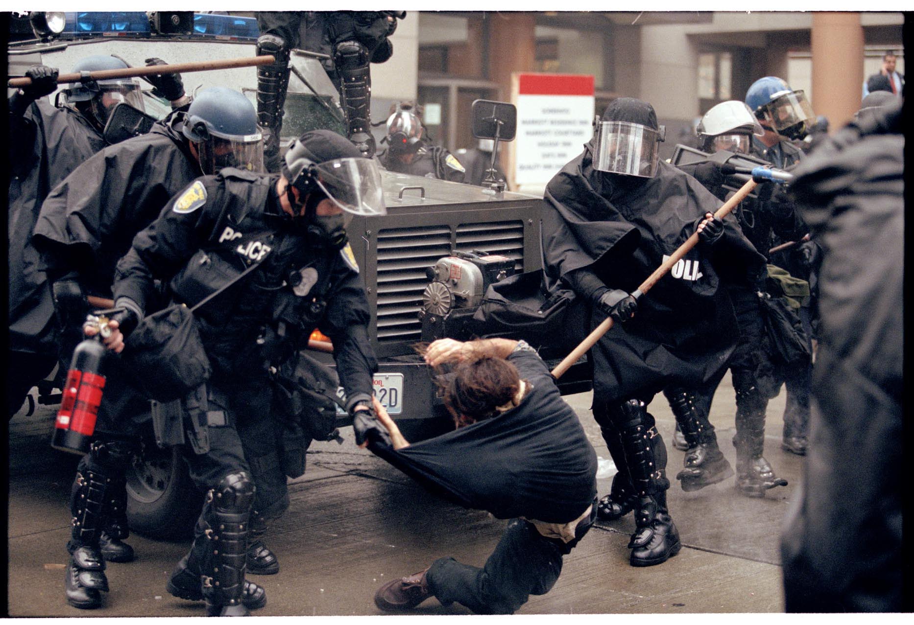 Image of Police pulling protester off armored vehicle at WTO protest, Seattle, November 30, 1999